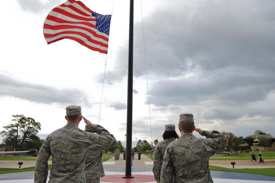 Airmen from the 74th Fighter Squadron and 23d Operations Support Squadron salute the flag during a retreat ceremony held at the President George W. Bush Air Park at Moody Field March 22, 2012, at Moody Air Force Base, Ga. Each month, members from different squadrons around the 23d Wing conduct the ceremony signaling the end of the official duty day.  (U.S. Air Force photo by Airman 1st Class Olivia Dominique/Released)