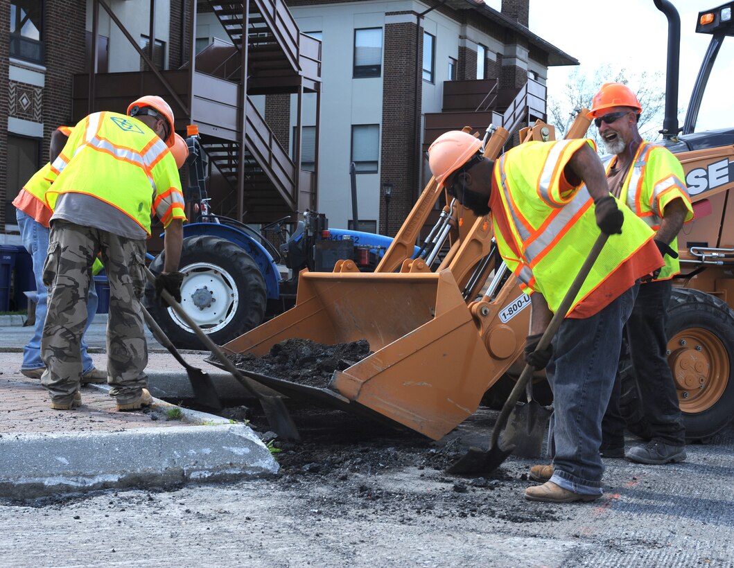 Construction workers shovel excess asphalt from the Air Combat Command Fitness Center parking lot March 22, 2012, at Langley Air Force Base, Va.  Gym patrons should prepare for changes to local traffic and parking patterns due to the construction. (U.S. Air Force photo by Airman 1st Class Teresa Cleveland/Released)