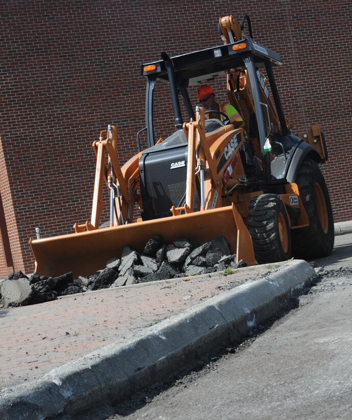Herb McNally, load operator, removes debris at the Air Combat Command Fitness Center at Langley Air Force Base, Va., March 22, 2012. Langley personnel can expect traffic and parking patterns to be affected by the various construction projects on the installation. (U.S. Air Force photo by Airman 1st Class Teresa Cleveland/Released)