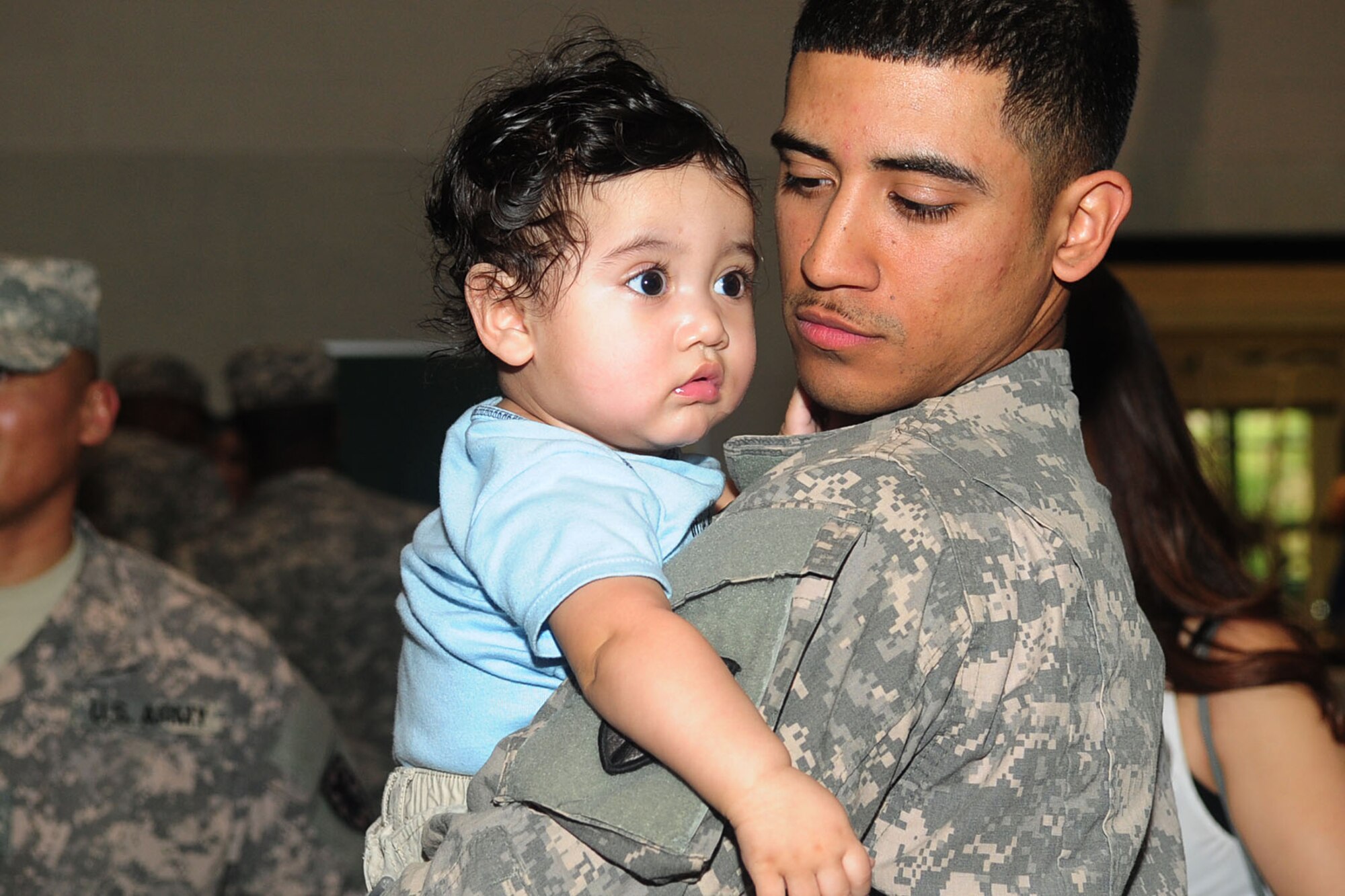 U.S. Army Spc. Michael Aguilar, 6th Battalion, Headquarters and Headquarters Detachment information technology specialist, greets his son for the first time in over a year during a homecoming ceremony at Fort Eustis, Va., March 22, 2012. After a year-long deployment, veterans, family and friends welcomed the Soldiers home. (U.S. Air Force photo by Staff Sgt. Ashley Hawkins/Released)