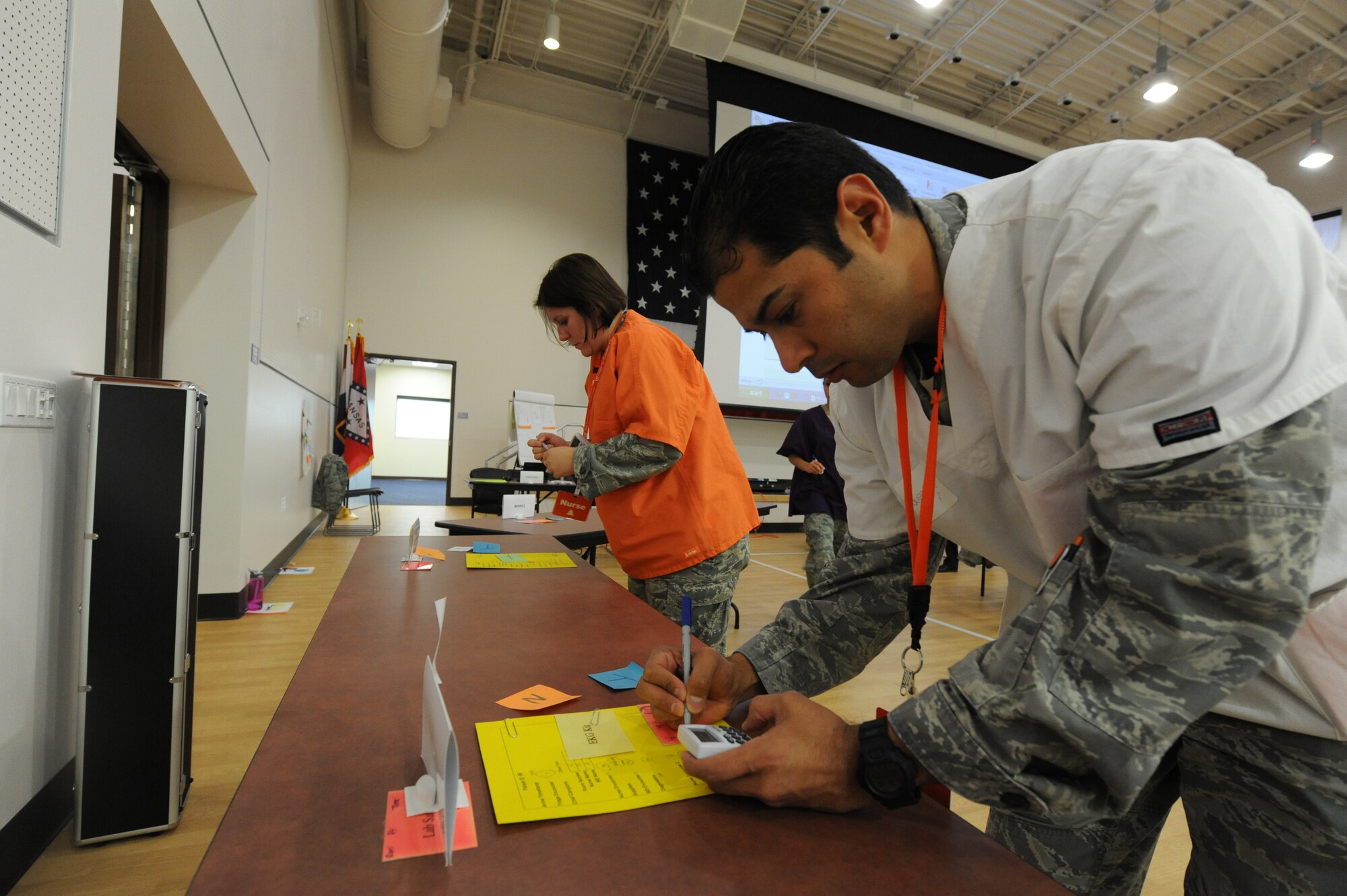 Tech. Sgts. Rolando Guerrero, 56th Medical Operations Squadron physical therapy NCO-in-charge, and Kristina O'Meara, 56th MDOS Family Health Flight education and training NCO-in-charge, review a "patient's" symptoms and prescribe treatment March 5 during the Lean For Healthcare course taught on Luke Air Force Base.  The course involved the more than 40 students running through an emergency room exercise where instructors timed each step in providing care to patients.  Students said the course taught them to see where they can remove wasted time and resources, allowing doctors and technicians more time to provide care while doing so with fewer resources.  (U.S. Air Force photo by Airman 1st Class Devante Williams)