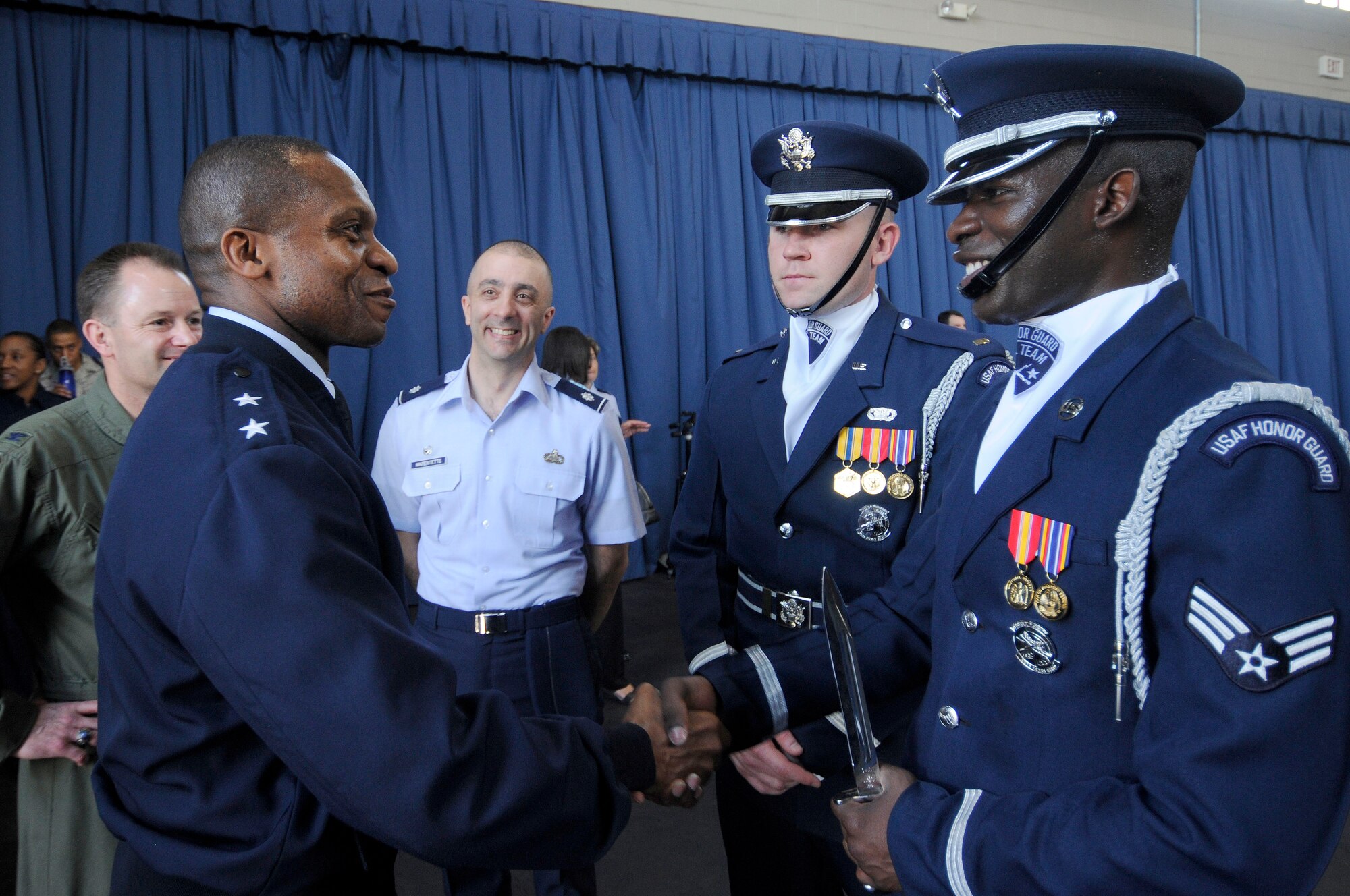 Maj. Gen. Darren W. McDew, Air Force District of Washington commander, speaks with Senior Airman Billy Degraffenreid, U.S. Air Force Honor Guard Drill Team, and 1st. Lt. Alexander Stanton, Drill Team flight commander, following a performance March 15 at Ceremonial Hall, Joint base Anacostia-Bolling, Washington D.C. Degraffenreid was responsible for the majority of training that went into successfully compiling a routine for the 2012 season. (U.S. Air Force photo by Senior Airman Steele C. G. Britton)