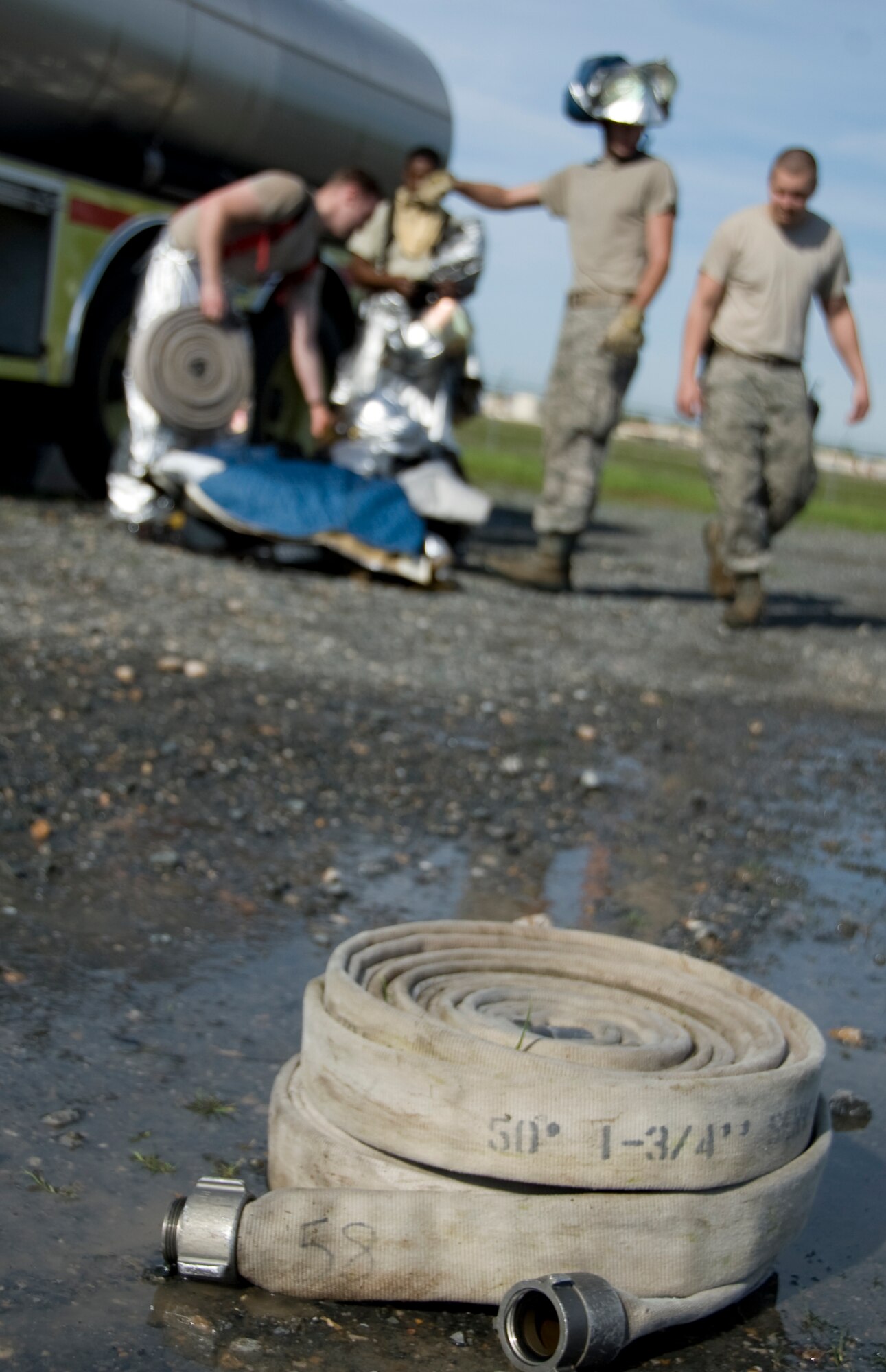 A rolled up hose rests on the ground as firefighters from the 2nd Civil Engineer Squadron clean up after a training exercise on Barksdale Air Force Base, La., March 22. Firefighters from the Shreveport Fire Department train at Barksdale annually to get recertified on fighting aircraft fires. (U.S. Air Force photo/Airman 1st Class Benjamin Gonsier)(RELEASED)
