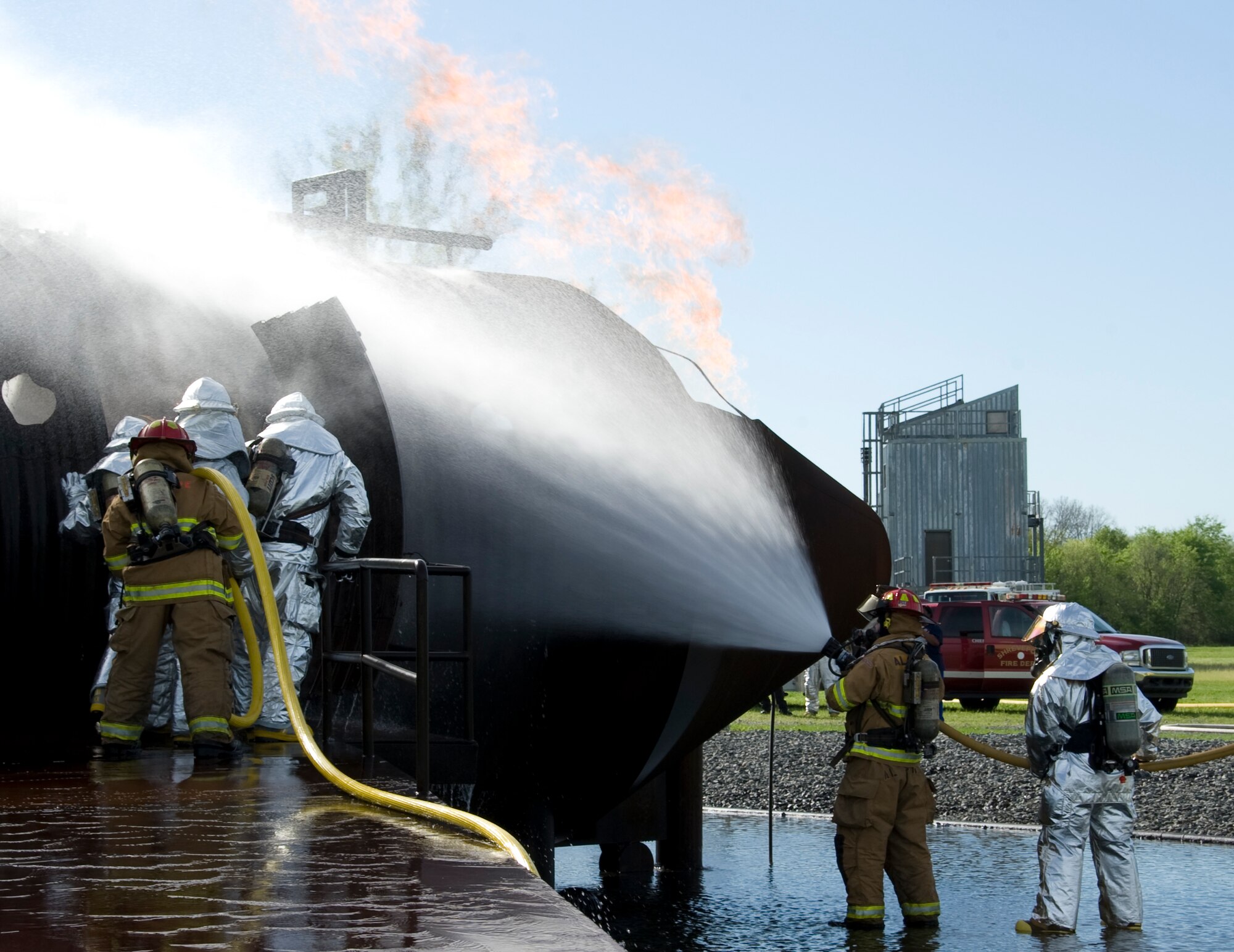 Firefighters from the Shreveport Fire Department and the 2nd Civil Engineer Squadron enter a burning mock B-52H Stratofortress on Barksdale Air Force Base, La., March 22. The temperatures inside the mock B-52 can reach more than 2,000 degrees Fahrenheit. (U.S. Air Force photo/Airman 1st Class Benjamin Gonsier)(RELEASED)
