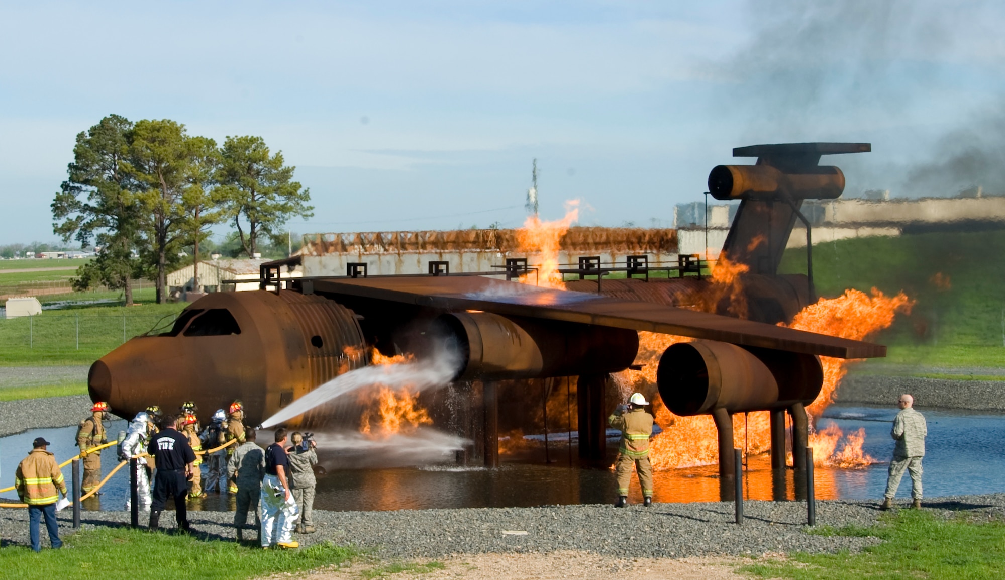 Firefighters from the Shreveport Fire Department and the 2nd Civil Engineer Squadron extinguish a fire on Barksdale Air Force Base, La., March 22. More than 20 firefighters from the SFD participated in the live burn training exercise to get recertified on fighting aircraft fires. (U.S. Air Force photo/Airman 1st Class Benjamin Gonsier)(RELEASED)
