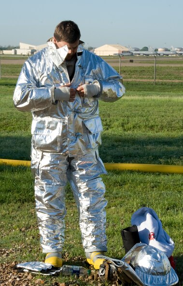 David Mcinnis, Shreveport Fire Department firefighter, dons a fire proximity suit on Barksdale Air Force Base, La., March 22. The fire proximity suit is used specifically for aircraft fires and protects the firefighter from thermal radiation. (U.S. Air Force photo/Airman 1st Class Benjamin Gonsier)(RELEASED)
