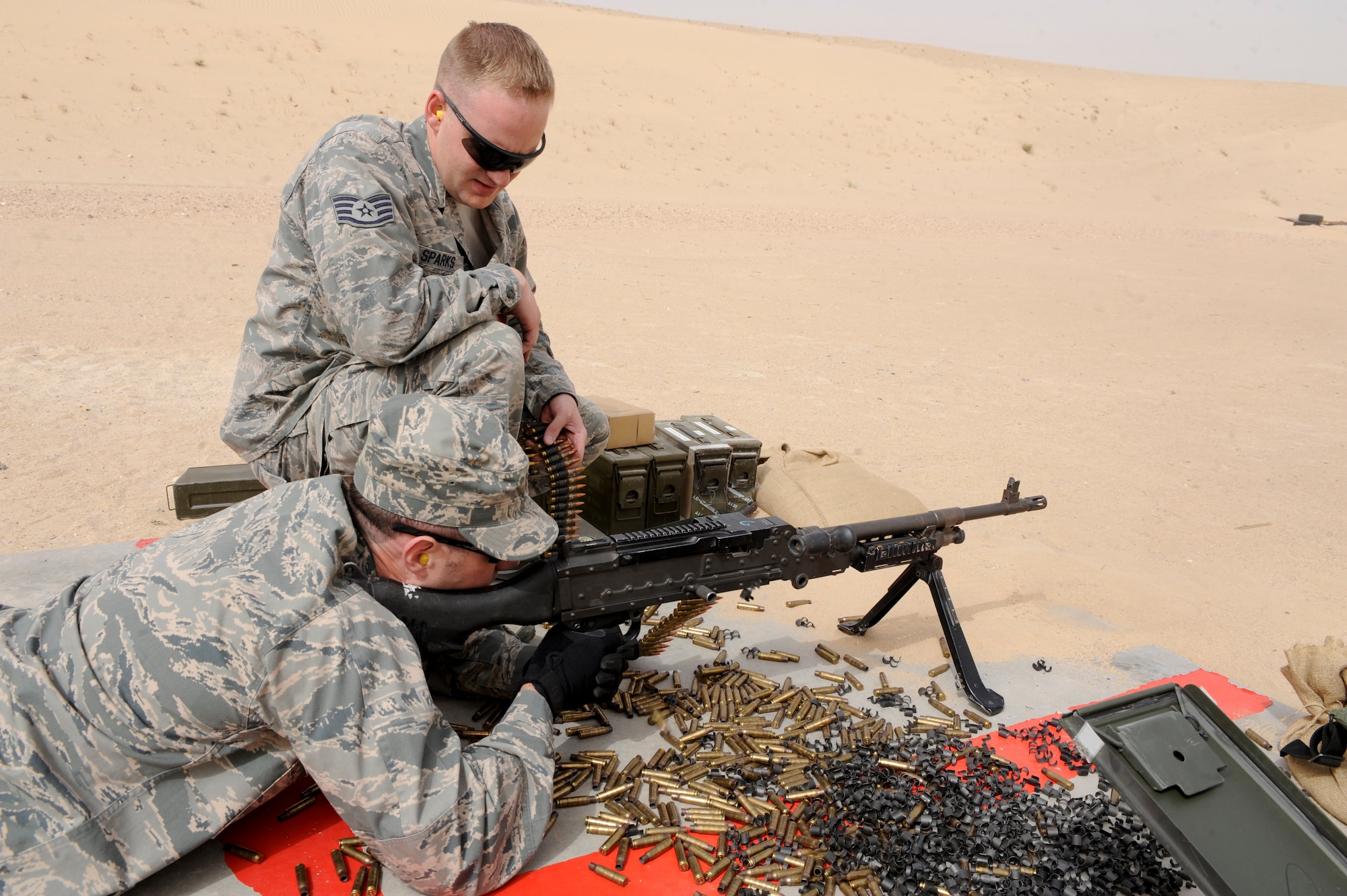 SOUTHWEST ASIA -- Staff Sgt. Larry Sparks, 332nd Expeditionary Security Forces Squadron combat arms instructor, watches as Major Joshua Anderson, 332nd Air Expeditionary Wing safety officer, fires an M240 machine gun at an undisclosed location in Southwest Asia, March 23, 2012. Anderson trained on two types of machine guns the 332nd ESFS uses on regular basis. Sparks is deployed from Holloman Air Force Base, N.M., and is native of Terre Haute, Ind. Anderson is deployed from Travis Air Force Base, Calif., and is a native of Tacoma, Wash. (U.S. Air Force photo by Staff Sgt. Joshua J. Garcia)