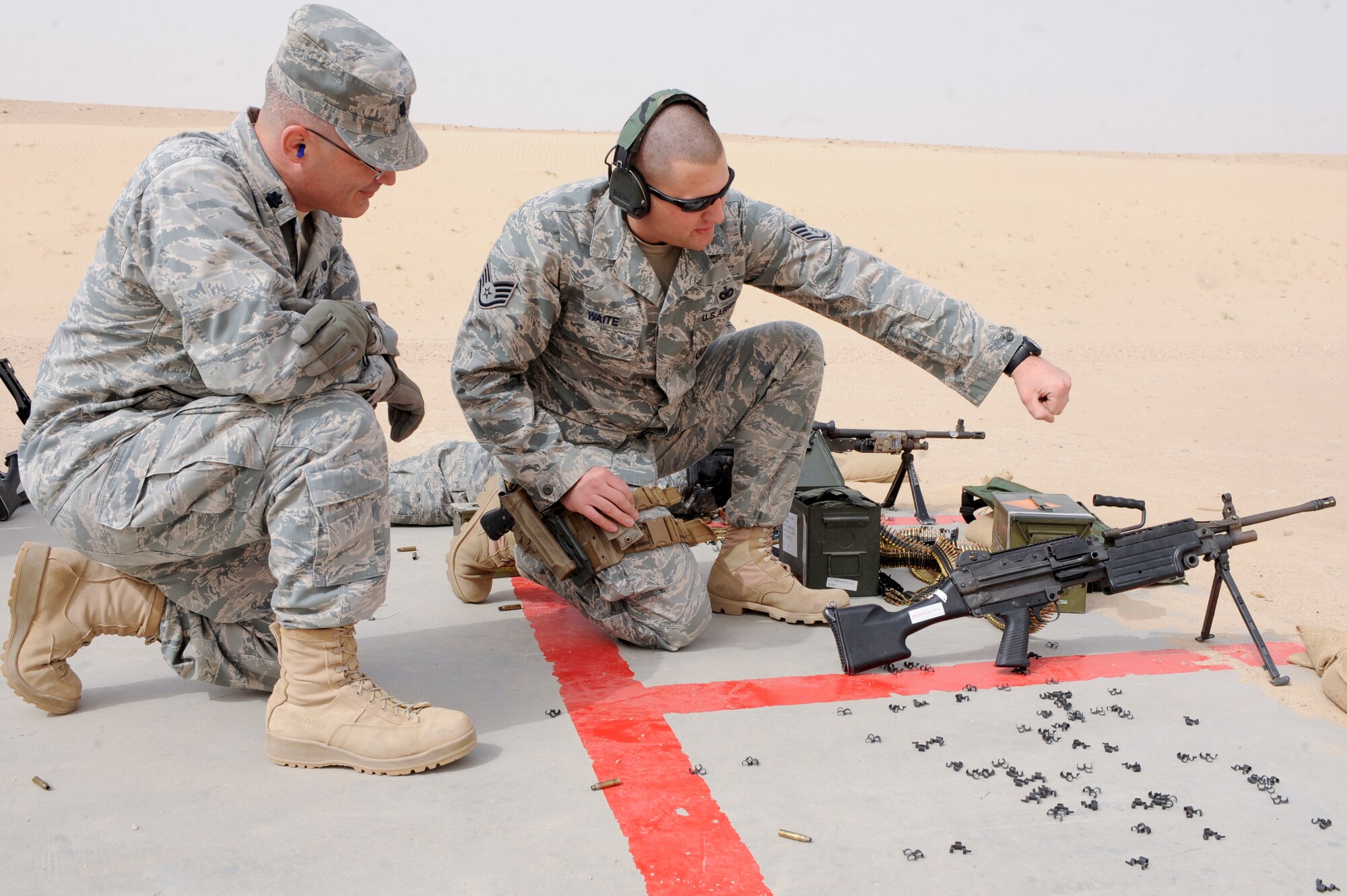 SOUTHWEST ASIA -- Staff Sgt. Todd Waite, 332nd Expeditionary Security Forces Squadron combat arms training and maintenance instructor, briefs Lt. Col. Ronald Spencer, 332nd Air Expeditionary Wing judge advocate, on how to properly handle the M249 machine gun at an undisclosed location in Southwest Asia, March 23, 2012. Spencer received training on the M249 and M240 as well as a refresher course on the M4 assault rifle. Spencer is deployed from Vandenberg Air Force Base, Calif., and is a native of Belpre, Ohio. Waite is deployed from Holloman Air Force Base, N.M., and is a native of Jackson, Mich. (U.S. Air Force photo by Staff Sgt. Joshua J. Garcia)