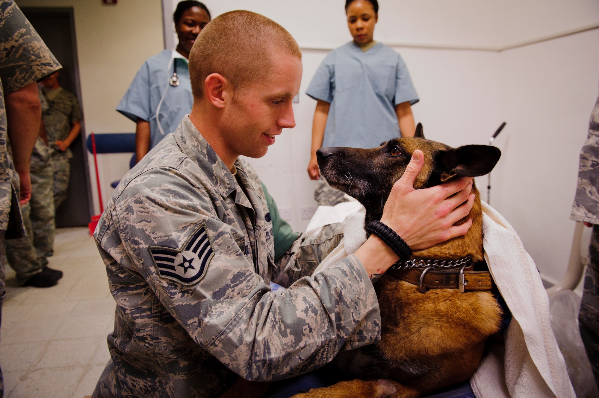 SOUTHWEST ASIA – U.S. Air Force Staff Sgt. Joel Brooks, 405th Expeditionary Security Forces Squadron dog handler, happily greets Roy, an eight-year-old Belgian Malinois military working dog, as Roy wakes up after undergoing an operation to fix his broken tooth here March 15, 2012. (U.S. Air Force photo/Staff Sgt. Nathanael Callon)