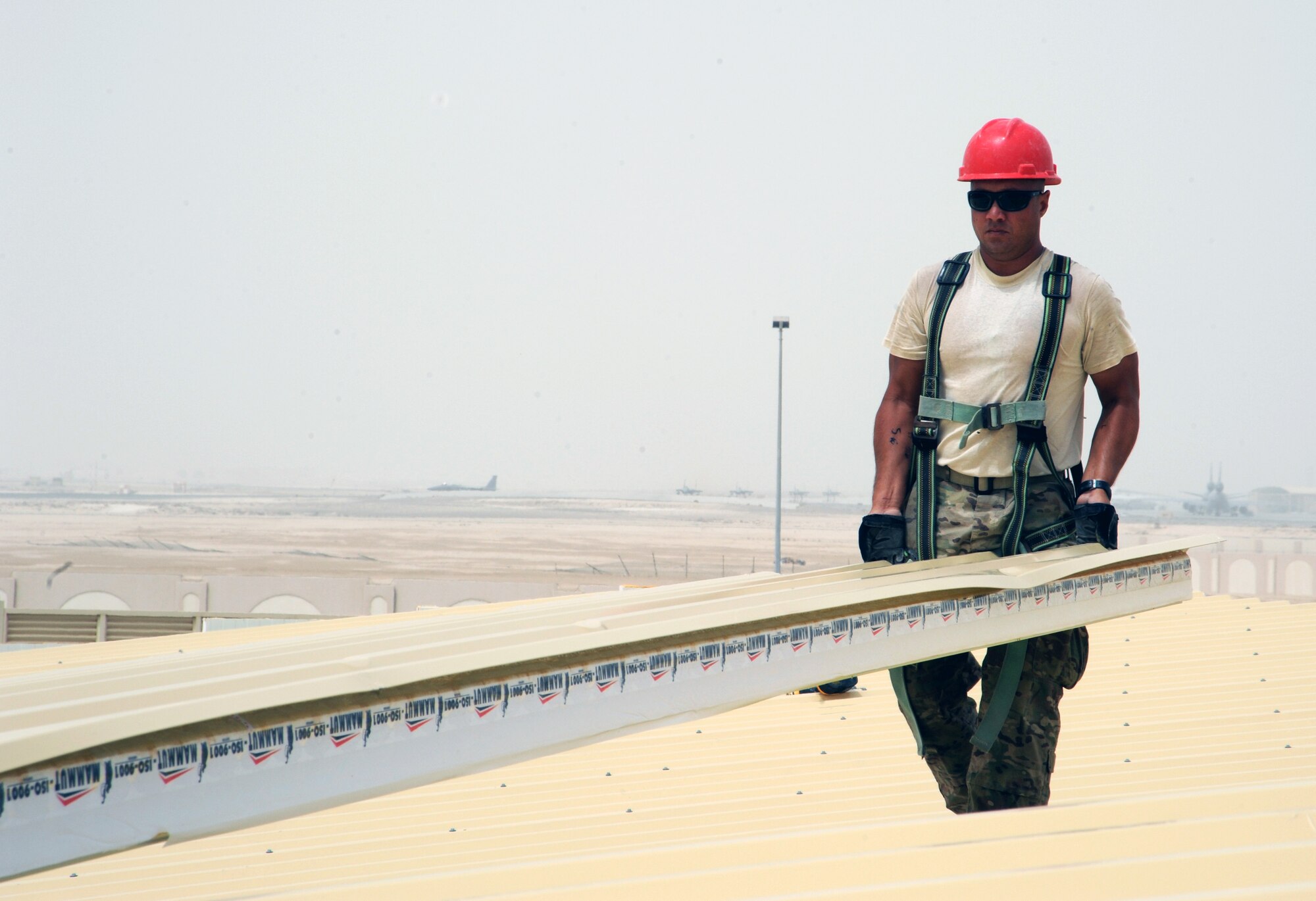 SOUTHWEST ASIA  - Tech. Sgt. Jason Caceres carries an insulated roof panel on a construction site March 22, 2012. Roughly 30 members of the 557th Expeditionary RED HORSE Squadron, or Rapid Engineer Deployable Heavy Operations Repair Squadron Engineers, are deployed to assist the 380th Air Expeditionary Wing by constructing three, 20,000 square-foot warehouses to store items sensitive to the harsh weather conditions in the area. (U.S. Air Force photo/1st Lt. Victoria Porto)