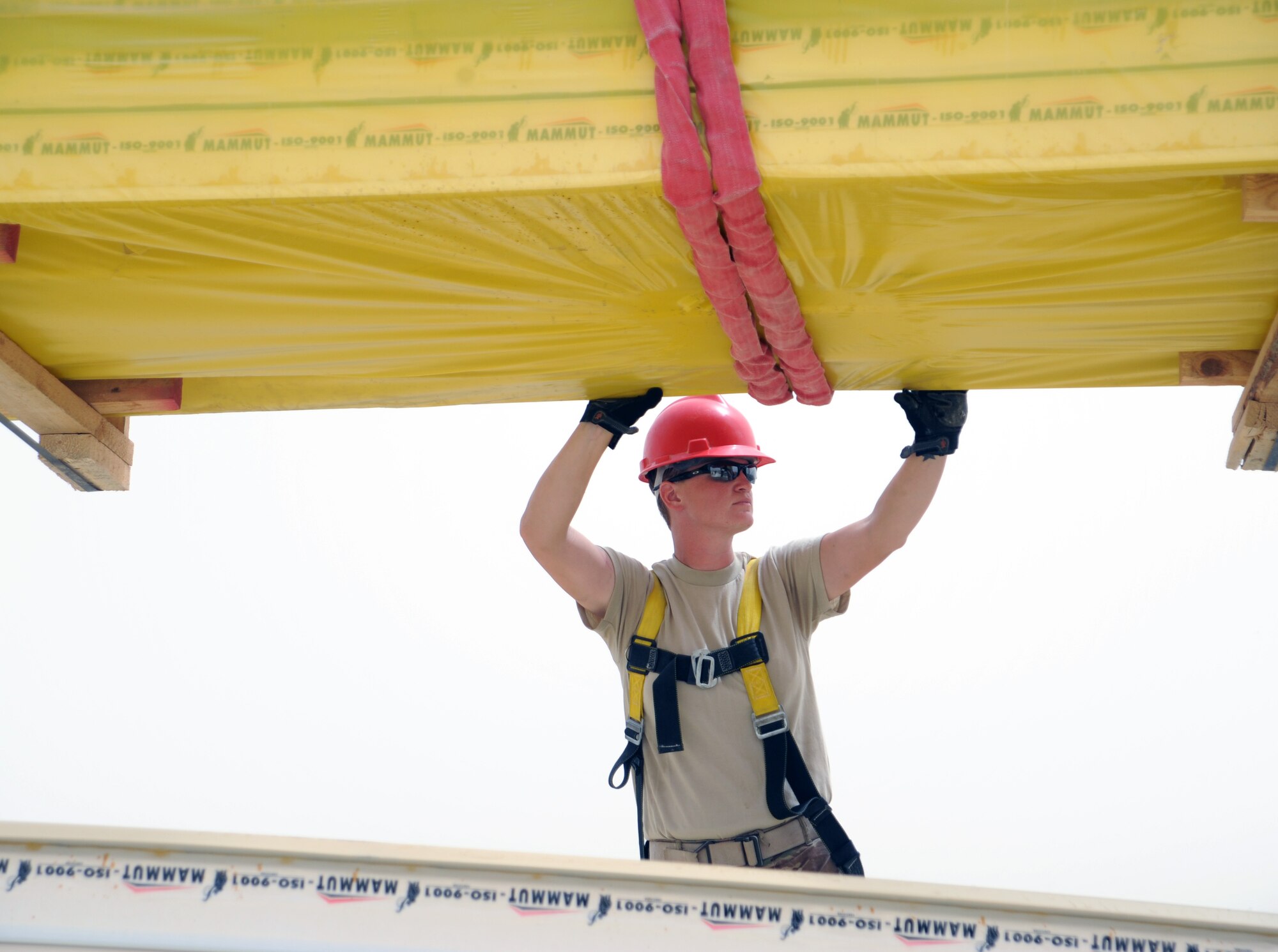 SOUTHWEST ASIA  - Staff Sgt. Kerstin Pieren guides insulated roof panels onto a construction site March 22, 2012. Roughly 30 members of the 557th Expeditionary RED HORSE Squadron, or Rapid Engineer Deployable Heavy Operations Repair Squadron Engineers, are deployed to assist the 380th Air Expeditionary Wing by constructing three, 20,000 square-foot warehouses to store items sensitive to the harsh weather conditions in the area. (U.S. Air Force photo/1st Lt. Victoria Porto)