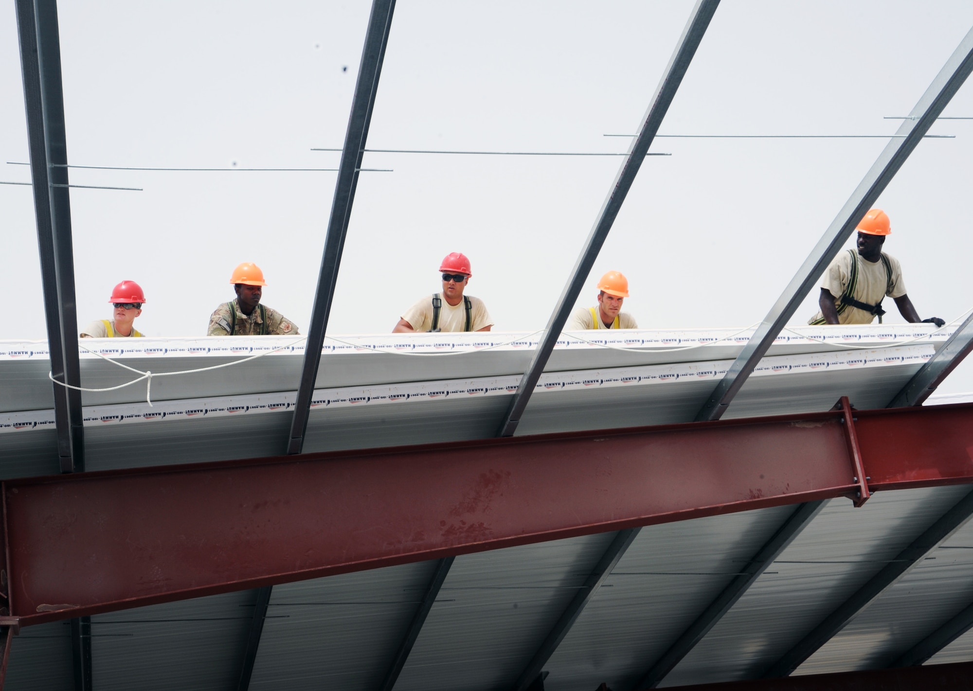 SOUTHWEST ASIA  - Members of the 557th Expeditionary RED HORSE Squadron move insulated roof panels into place March 22, 2012. Roughly 30 Rapid Engineer Deployable Heavy Operations Repair Squadron Engineers are deployed to assist the 380th Air Expeditionary Wing by constructing three, 20,000 square-foot warehouses to store items sensitive to the harsh weather conditions in the area. (U.S. Air Force photo/1st Lt. Victoria Porto)
