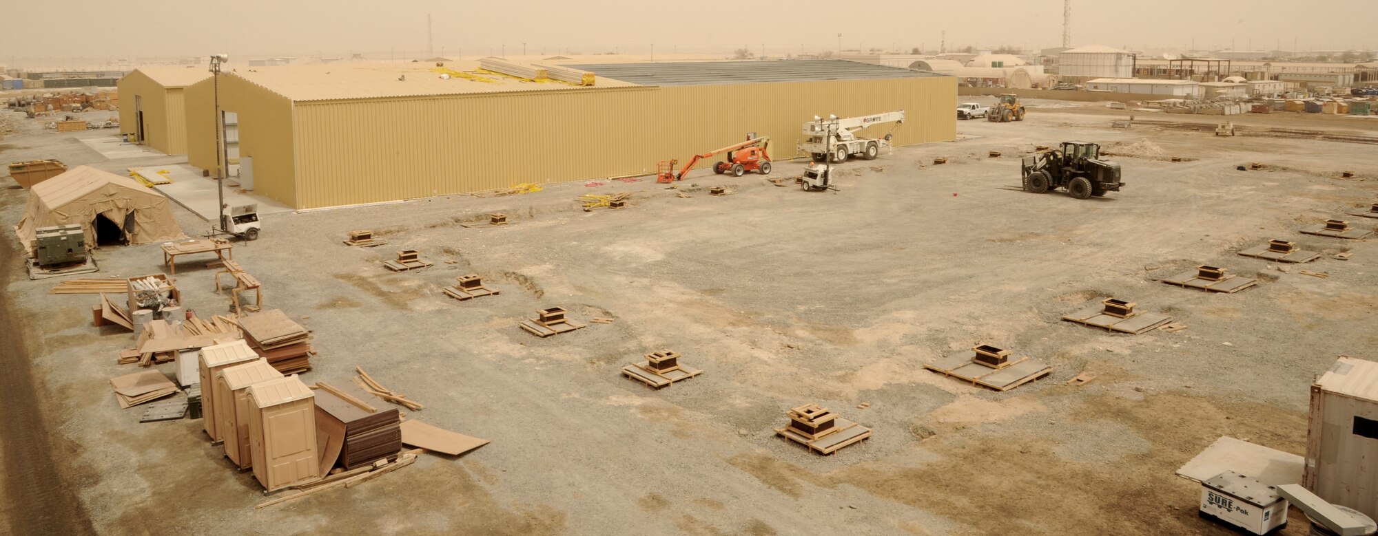 SOUTHWEST ASIA - Airmen construct three, 20,000 square-foot warehouses so the 380th Air Expeditionary Wing can store items sensitive to the harsh weather elements of the area March 22, 2012.  Roughly 30 Rapid Engineer Deployable Heavy Operations Repair Squadron Engineers are deployed to assist the 380th AEW as the base mission evolves to an enduring operation. RED HORSE units can go anywhere in the world and build whatever's needed there, all while being as self-sufficient as possible. (U.S. Air Force photo/Tech. Sgt. Arian Nead)
