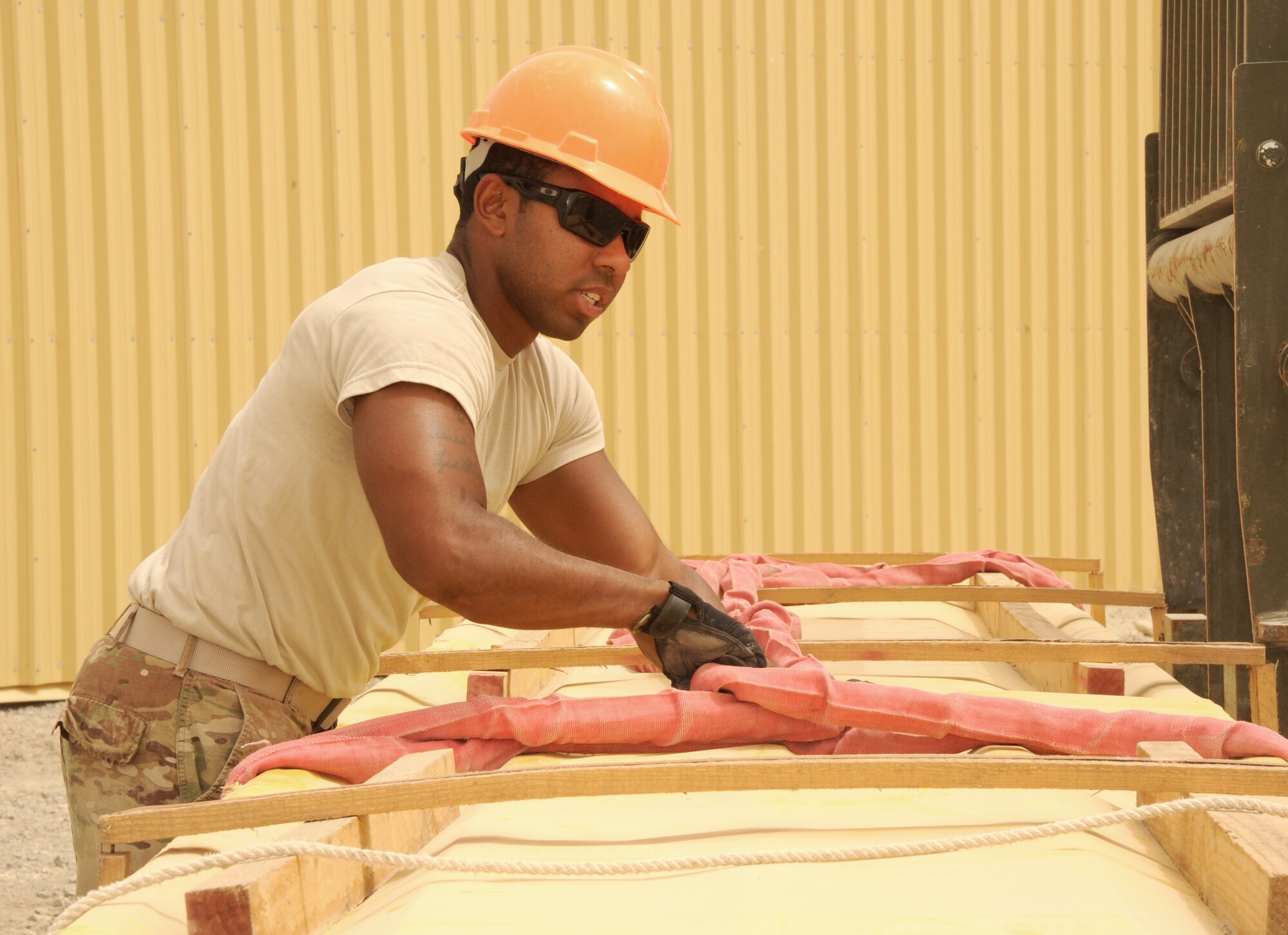 SOUTHWEST ASIA - Senior Airman Taurean McClain secures a stack of insulated roof panels before they are lifted to the top of a construction site March 22, 2012. Roughly 30 Rapid Engineer Deployable Heavy Operations Repair Squadron Engineers are deployed to assist the 380th Air Expeditionary Wing as the base mission evolves to an enduring operation. RED HORSE units can go anywhere in the world and build whatever's needed there, all while being as self-sufficient as possible. McClain is deployed from Seymour Johnson Air Force Base, N.C. (U.S. Air Force photo/Tech. Sgt. Arian Nead)

