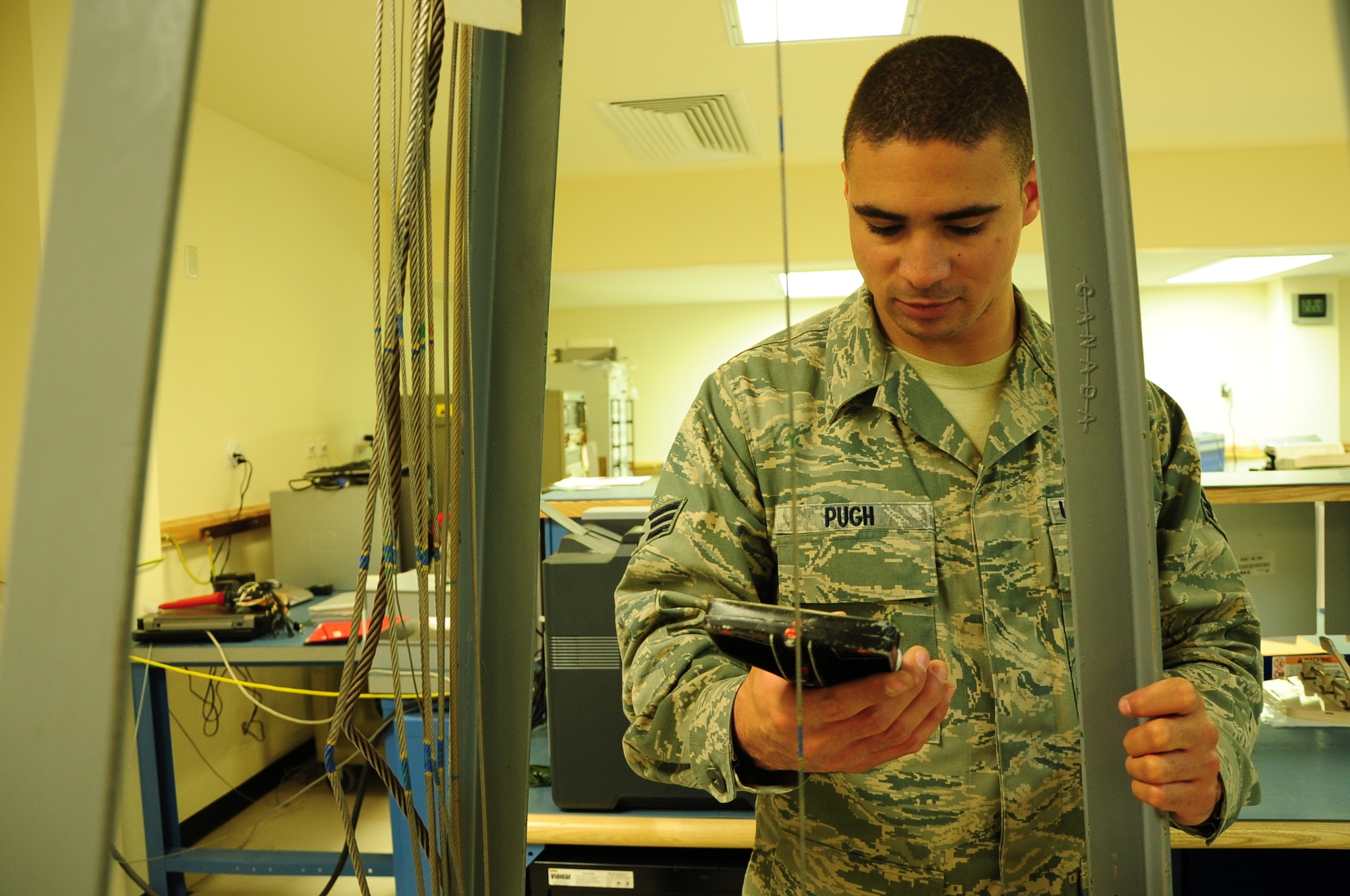 Senior Airman Chace Pugh, a Precision Measurement Equipment Laboratory technician deployed from Edwards Air Force Base, Calif., tests the tension on an aircraft wire at the 379th Expeditionary Maintenance Squadron PMEL shop here March 13. PMEL is responsible for the proper calibration of more than 16,000 items ranging from screws to radar systems. Pugh is a native of El Paso Texas. (U.S. Air Force photo/ Senior Airman Michael Charles)