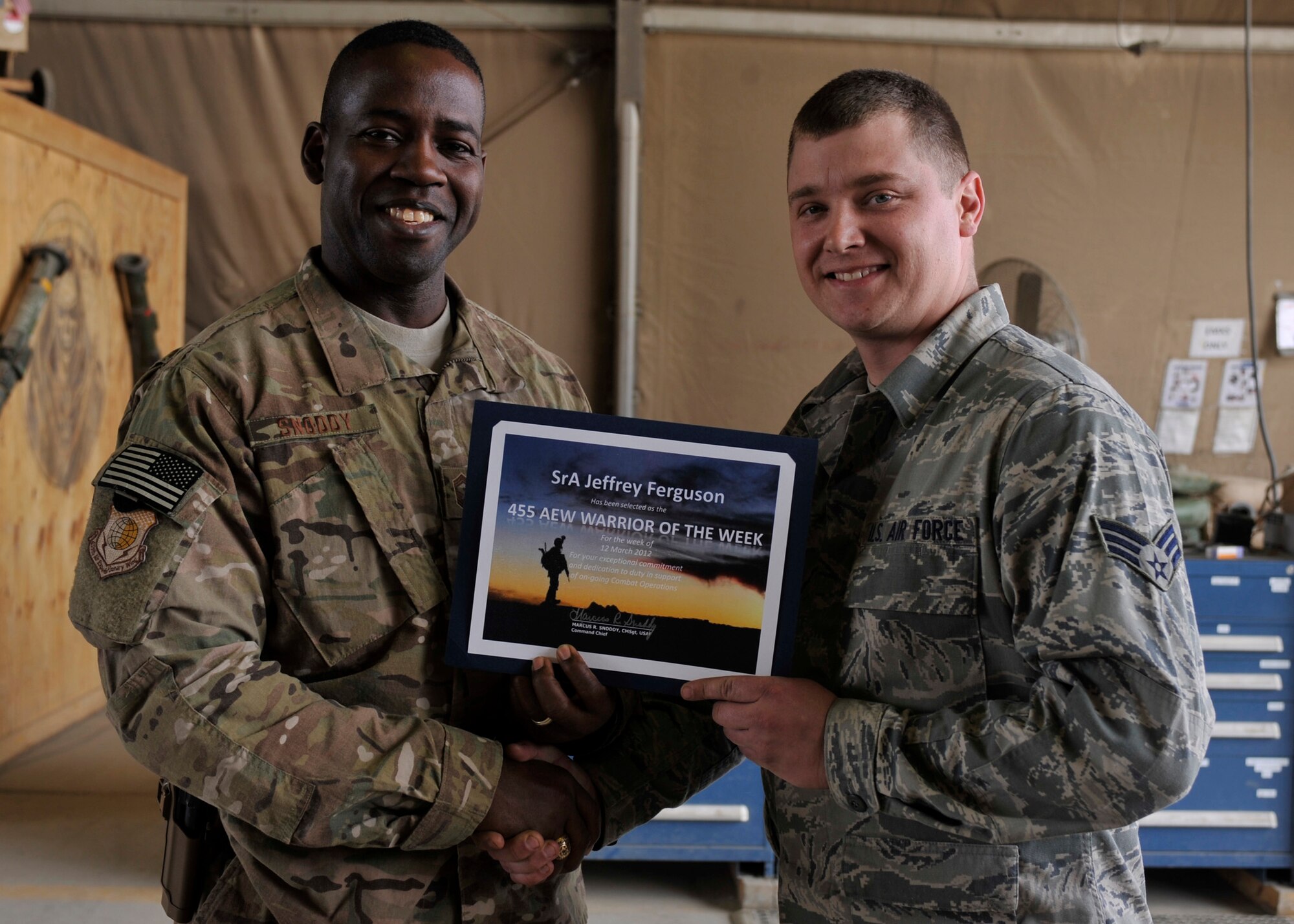 BAGRAM AIRFIELD, Afghanistan—Senior Airman Jeffrey Ferguson receives the Warrior of the Week award from 455th Air Expeditionary Wing Command Chief Chief Master Sgt. Marcus Snoddy at Bagram Airfield, Afghanistan, March 22, 2012. Ferguson is an A-10 combat armament systems team member with the 455th Expeditionary Maintenance Squadron and earned the Warrior of the Week award for his hard work and dedication to excellence. (U.S. Air Force photo/Airman 1st Class Ericka Engblom)
