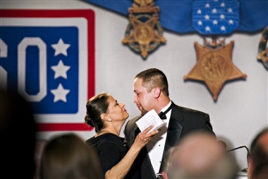 Terri Santiago kisses her son, retired Marine Corps Sgt. Christopher Santiago, right, after he presented her the Col. John Gioia Patriot Award during the USO of Metropolitan Washington 30th Annual Awards Dinner in Arlington, Va. March 22, 2012.