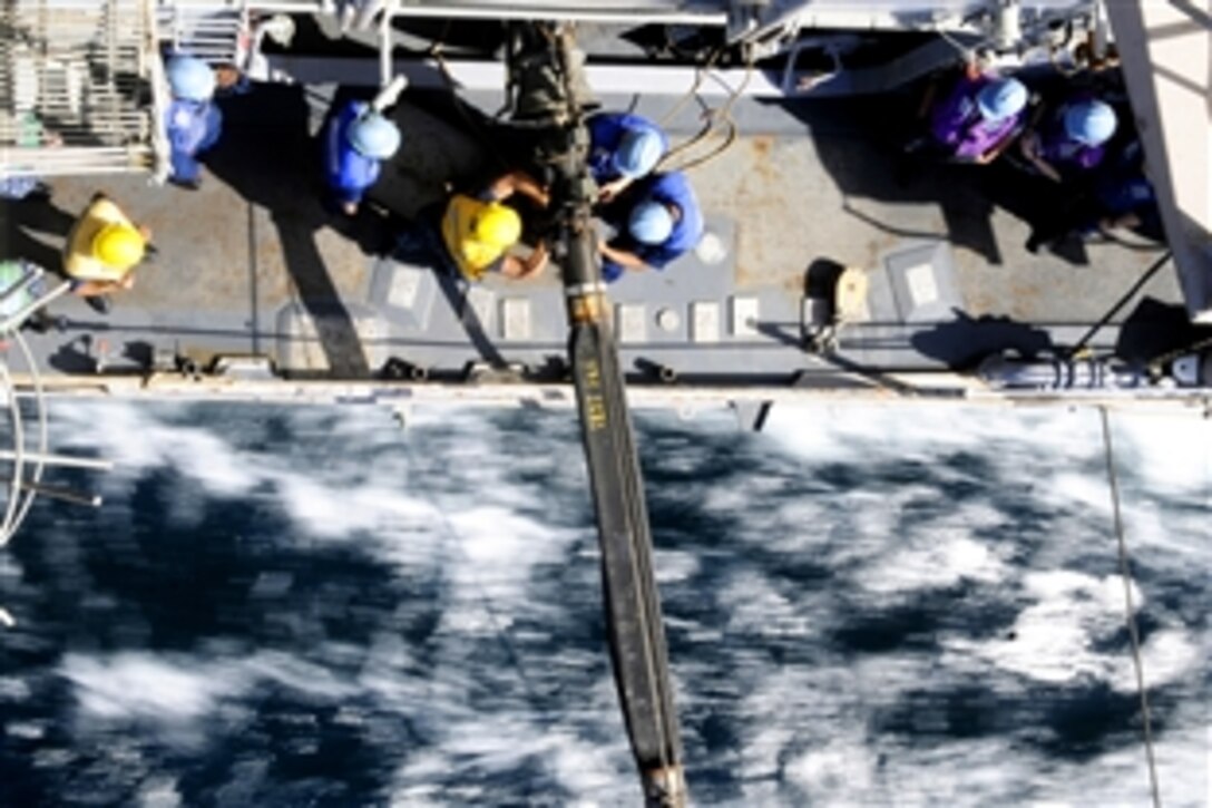 U.S. sailors tie down a refueling probe aboard the USS Bunker Hill during an underway replenishment with the USNS Bridge in the Arabian Sea, March 16, 2012. Bunker Hill is deployed to the U.S. 5th Fleet area of responsibility conducting maritime security operations and theater security operation efforts. 