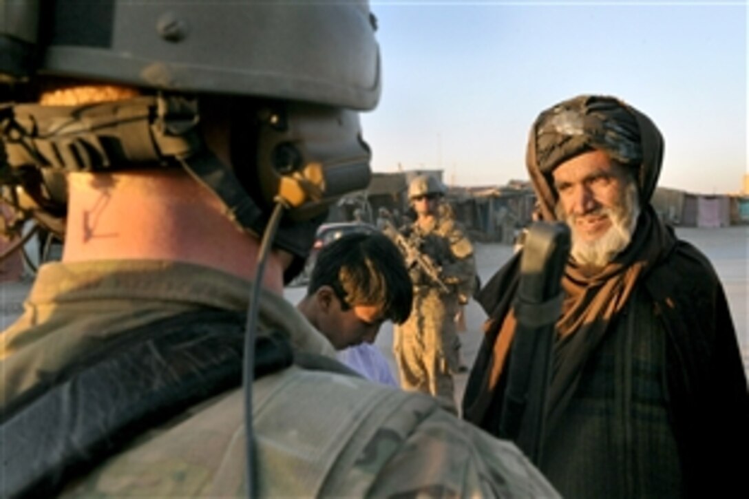 Coalition forces talk with local merchants about recent attacks by insurgents during a dismounted patrol in the Muqer district, Ghazni province, Afghanistan, March 21, 2012. The insurgent attack resulted in multiple Afghan civilian killed and injured. Coalition forces conducted a dismounted patrol to engage merchants, villagers and key leaders in the area. 