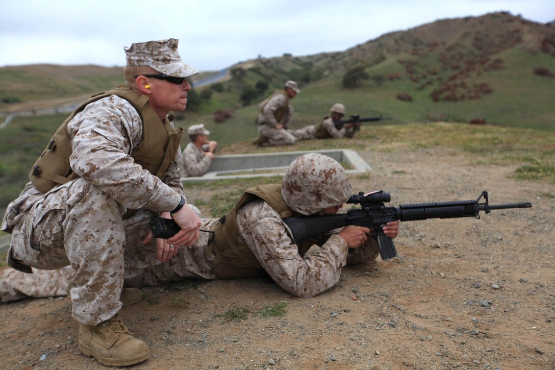 Sgt. Jeremy P. Sears, a range coach with Headquarters and Support Battalion, Marine Corps Base Camp Pendleton, gives advice to a Marine during an unknown distance live-fire training exercise, March 23. Marines with Headquarters and Support Battalion participated in training exercises to maintain combat readiness and enhance basic warrior skills.