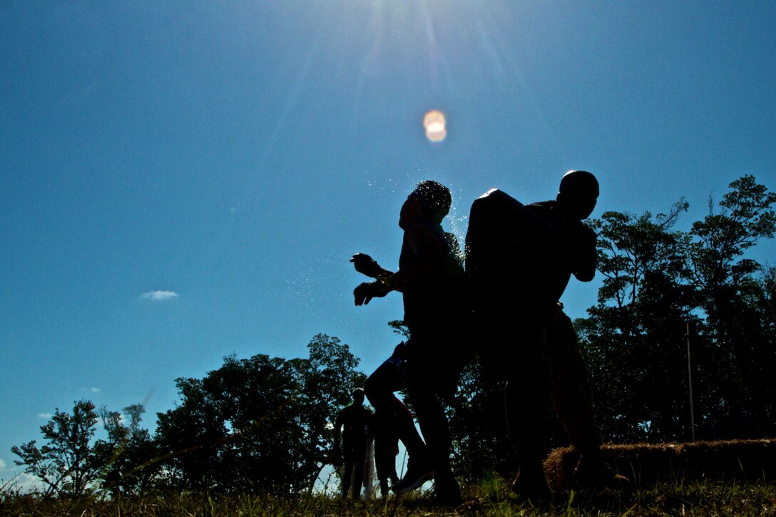 Staff Sergeant Jonathan Castro, the staff non-commissioned officer-in-charge of Recruiting Substation South Dade, blocks the path for a participant in the Miami Superhero Scramble March 24, 2012. The Superhero Scramble is 3.5 miles of wicked terrain with 18 or more obstacles including major water crossings. The race is designed to test the competitors’ resilience, strength and endurance. Marines from Recruiting Station Fort Lauderdale, Fla., brought a unique intensity to the event by putting participants to the test with a series of Marine inspired exercises, including ammo can lifts, a log run and burpees.