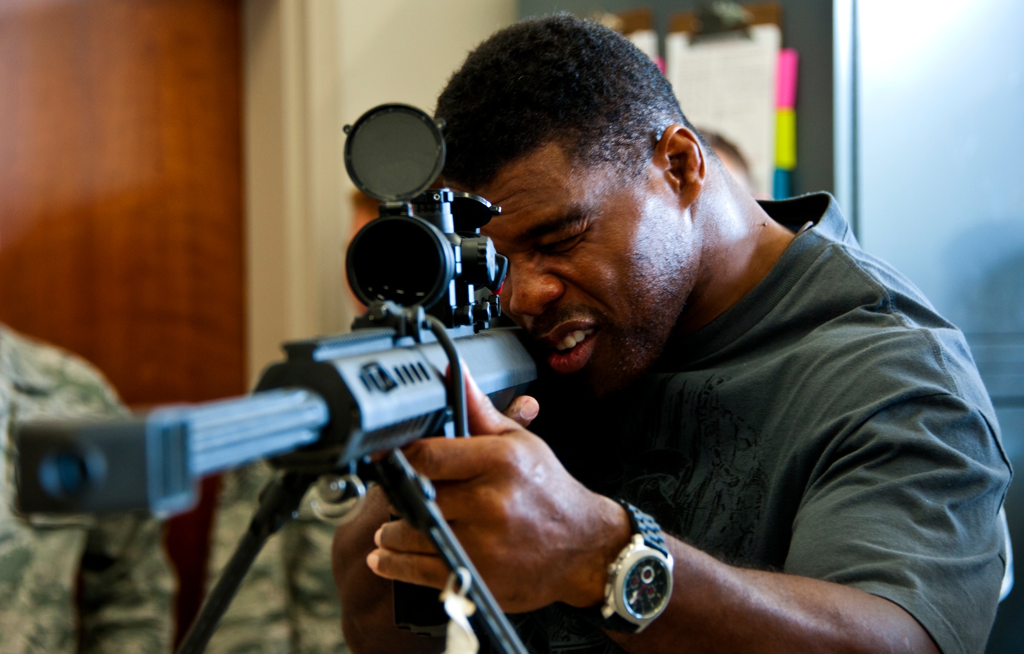 Herschel Walker aims the Barrett M82 rifle while visiting the explosive ordnance disposal flight March 22 at Eglin Air Force Base, Fla. Between speaking engagements, Walker visited the EOD flight, fitness assessment center and flew in a CV-22 during his visit to the base.  Walker spoke twice to large crowds of Team Eglin members about his life, career and the emotional and mental struggles he encountered throughout.  His message was about resiliency and the importance of asking for help.  (U.S. Air Force photo/Samuel King Jr.)