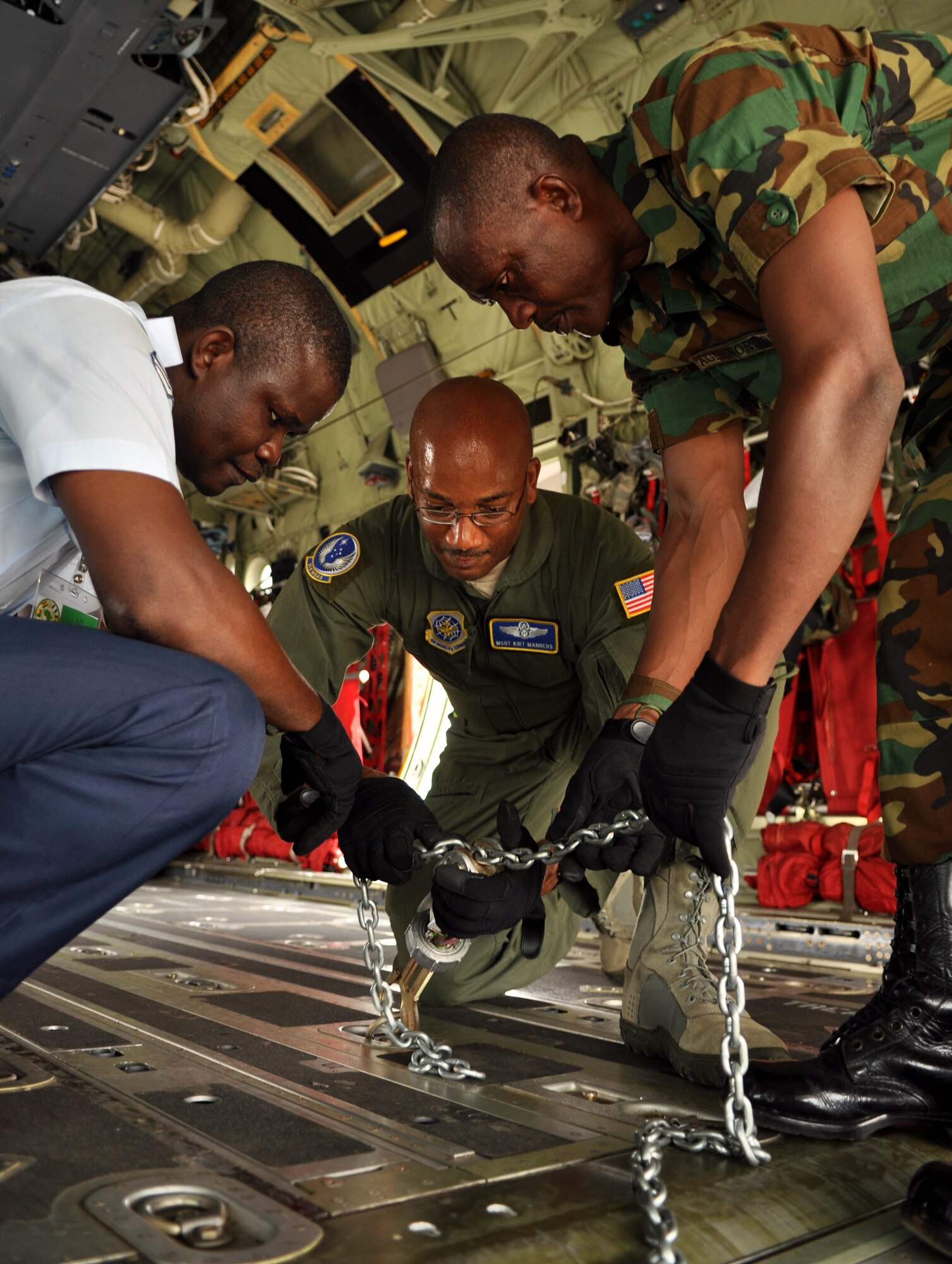 ACCRA, Ghana -- Master Sgt. Kirt Manners, center, 818th Mobility Support Advisory Squadron, assists Ghanaian air force members in preparing to secure cargo to an aircraft before the capstone event of African Partnership Flight 12-2 March 21 here. U.S. Air Forces Africa APF 12-2 is a military-to-military partnership building exercise event providing all air forces involved the opportunity to exchange techniques and learn from one another. (U.S. Air Force photo by Senior Airman Natasha Stannard/Released)