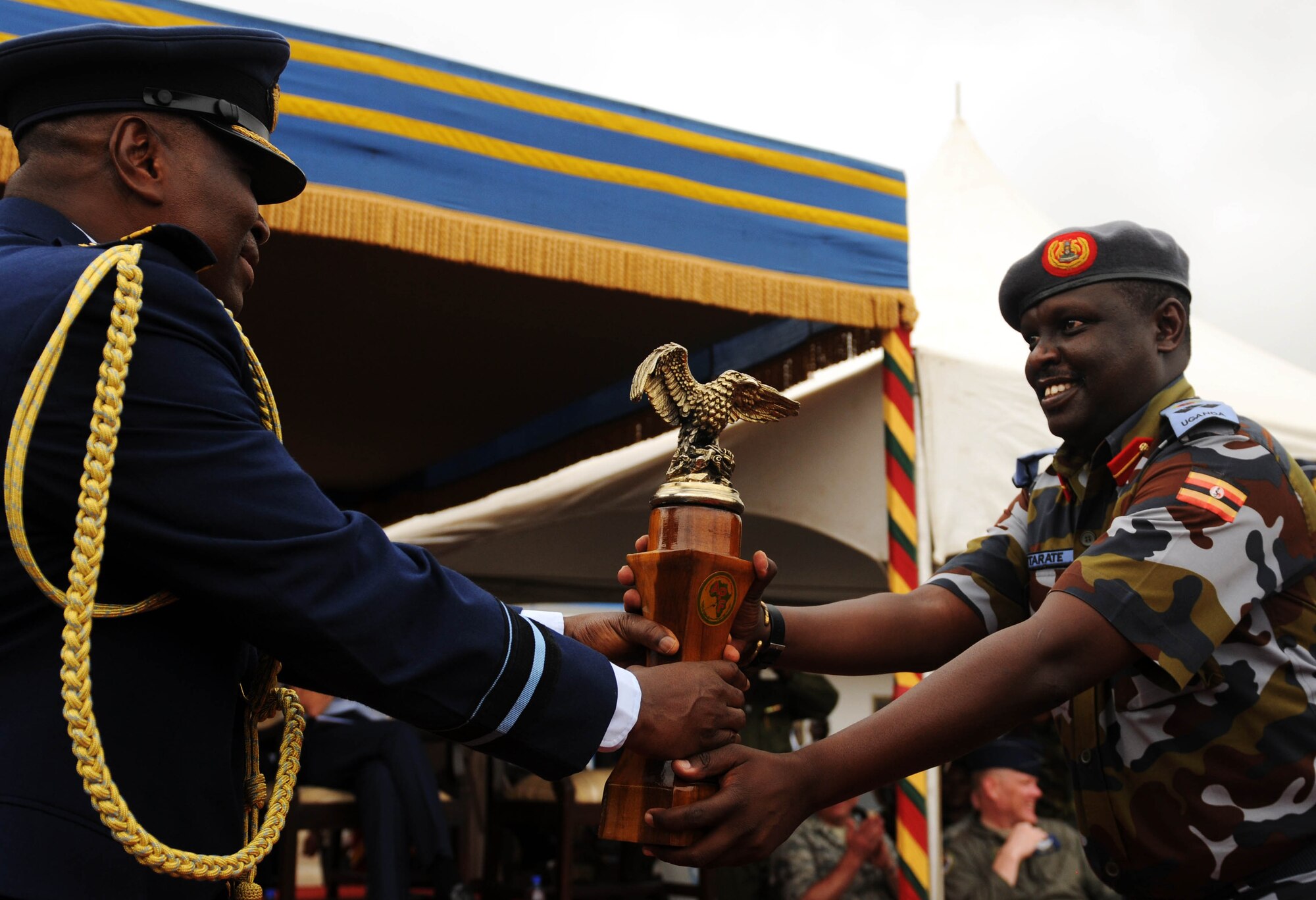 ACCRA, Ghana -- Ghanaian air force Air Commodore Emmanuel Obeng, GAF headquarters base commander,  passes the inaugural African Partnership Flight trophy to Ugandan air force chief of staff, Brig. Gen. Moses Rwakitarate March 23 during the APF 12-2 closing ceremony here. Uganda is host nation for next year’s APF event.  APF 12-2 is military-to-military partnership building exercise that gave Ghanaian, Togolese, Senegalese, Nigerian, Benin and U.S. Air Force the opportunity to share ideas, techniques and practices to strengthen each nation’s air-security.  (U.S. Air Force photo by Senior Airman Natasha Stannard/Released)
