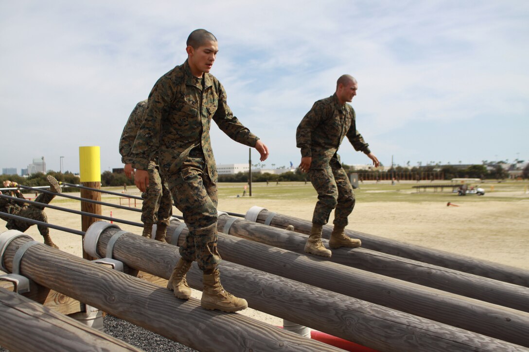 Recruits of Company F, 2nd Recruit Training Battalion  balance themselves as they quickly walk down log beams to the next obstacle on the "O-course" aboard Marine Corps Recruit Depot San Diego March 24. The course focuses on upper-body strength and has a series of elevated bars and logs, as well as walls the allow recruits to try different methods to climb over.