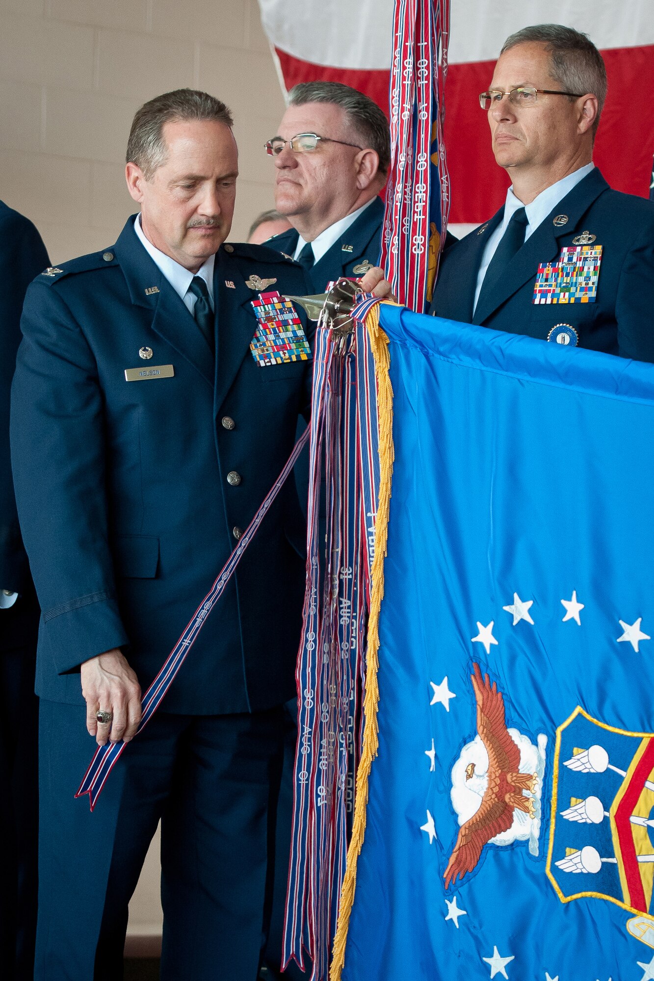 Col. Greg Nelson, commander of the Kentucky Air National Guard's 123rd Airlift Wing, pins a streamer on the wing's guidon during an awards ceremony held March 18, 2012, at the Kentucky Air National Guard Base in Louisville, Ky. The streamer represents the wing's 15th Air Force Outstanding Unit Award, a nearly unprecedented achievement in the history of the U.S. Air Force. Only three other units are believed to have earned 15 AFOUAs. (U.S. Air Force photo by Senior Airman Maxwell Rechel)