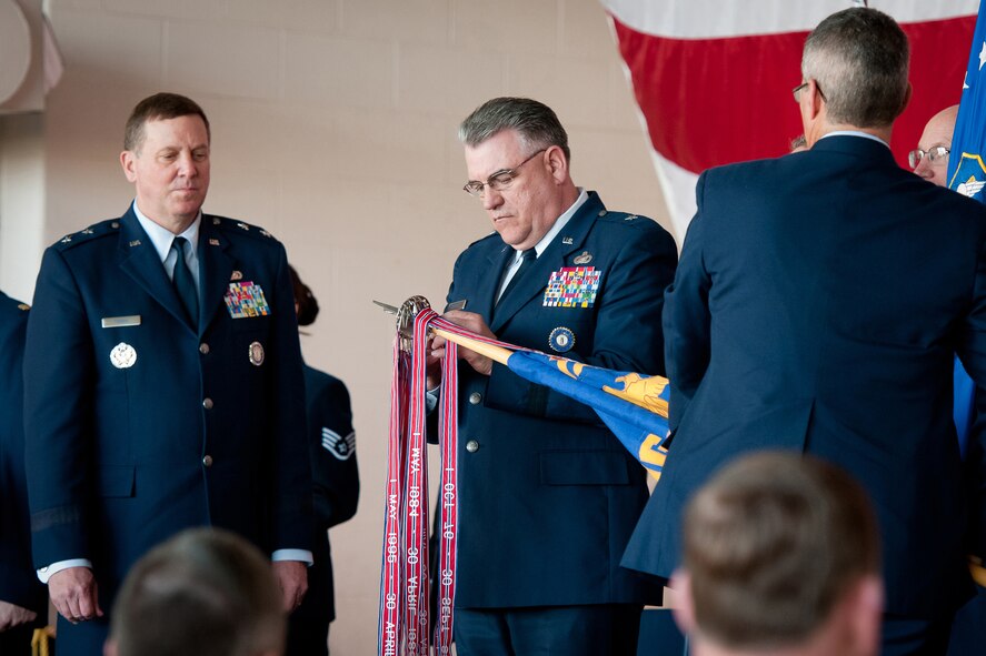 Brig. Gen. Michael Dornbush, chief of the joint staff for Joint Forces Headquarters-Kentucky, pins a streamer on the flag of Kentucky Air National Guard Headquarters during an awards ceremony held March 18, 2012, at the Kentucky Air National Guard Base in Louisville, Ky. The streamer represents Headquarters' 9th Air Force Organizational Excellence Award. (U.S. Air Force photo by Senior Airman Maxwell Rechel)