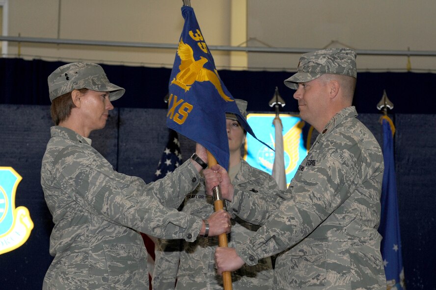 U.S. Air Force Col. Cheryl Minto, left, 35th Maintenance Group commander, passes the guidon to Maj. Rognald Christensen, 35th Aircraft Maintenance Squadron commander, during a change of command ceremony at Misawa Air Base, Japan, March 26, 2012. The guidon symbolizes the relinquishment of command from the outgoing commander to the incoming commander. Christensen replaced Lt. Col. David Ruth as the 35 AMXS commander. (U.S. Air Force photo by Tech. Sgt. Marie Brown/Released)