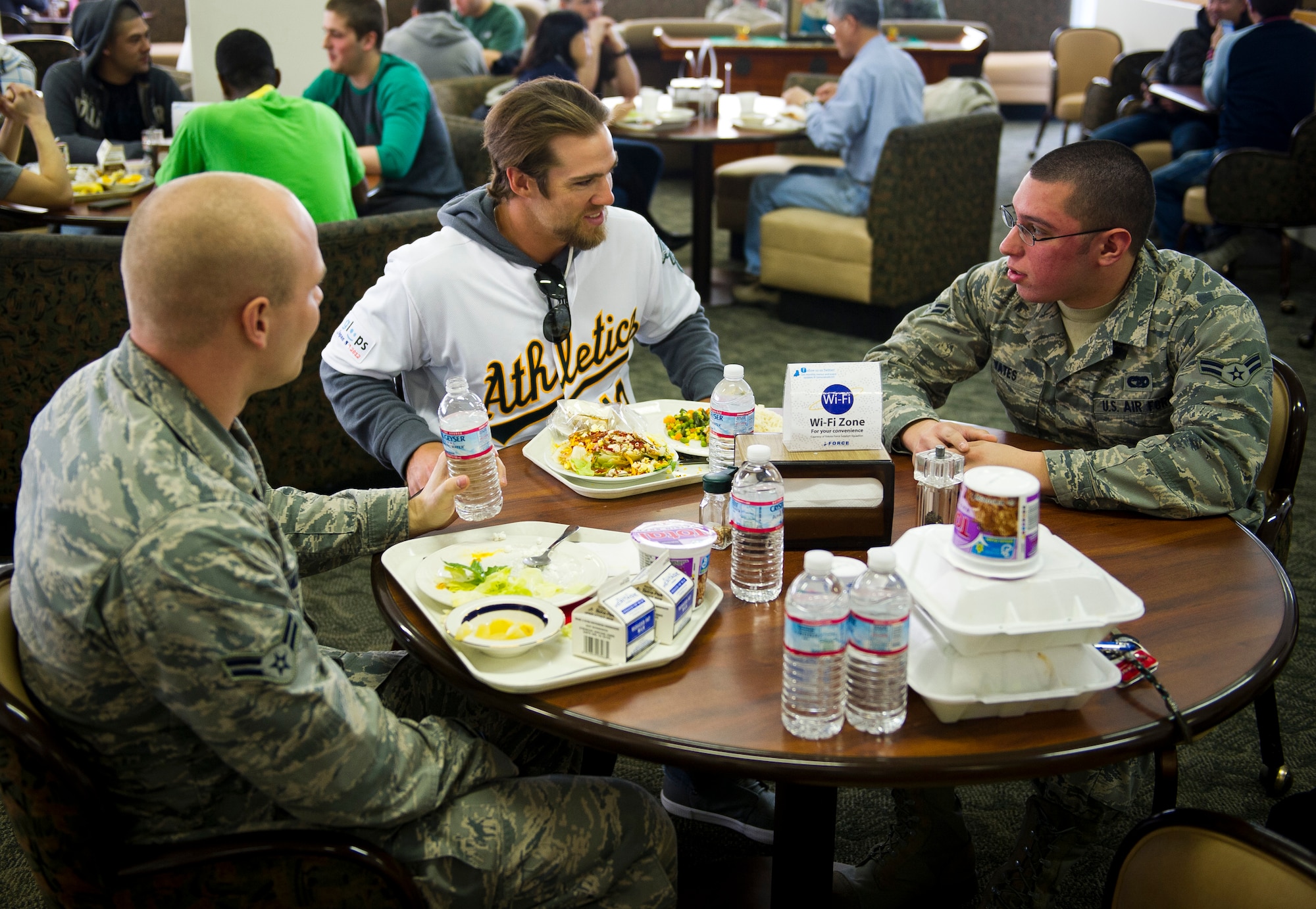 YOKOTA AIR BASE, Japan -- Collin Cowgill, Oakland Athletics right fielder, eats with Airman 1st Class Luke Vanlandegen and Airman 1st Class Gary Yates, 730th Air Mobility Squadron, at the Samura Cafe here at Yokota Air Base March 25, 2012. Eight players from the Athletics came to Yokota to meet with kids eat lunch with Airmen and sign autographs. (U.S. Air Force photo/Staff Sgt. Chad C. Strohmeyer)