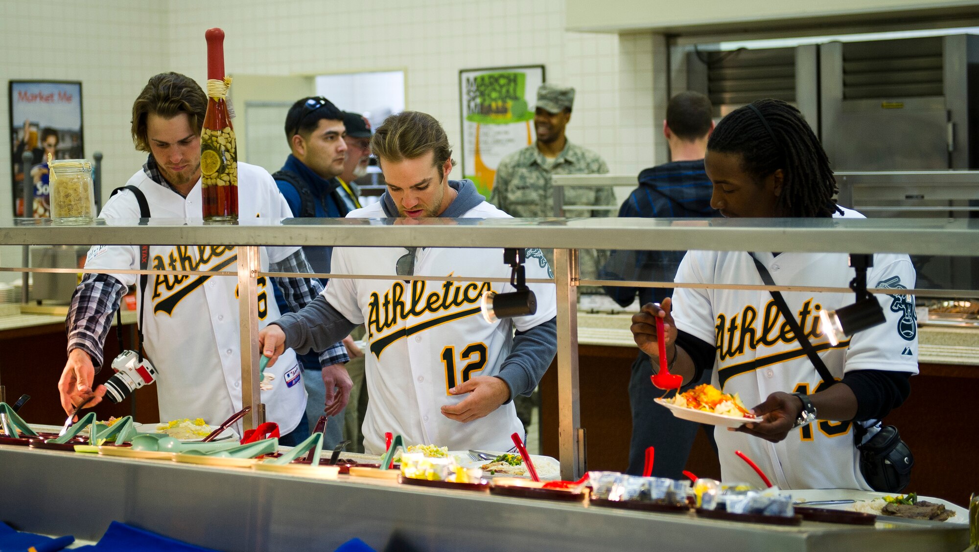 YOKOTA AIR BASE, Japan -- Josh Reddick, Collin Cowgill and Jemile Weeks, Oakland Athletics, get food at the Samuari Cafe here at Yokota Air Base, Japan, March 25, 2012. The players ate with Airmen and signed autographs. (U.S. Air Force photo/Staff Sgt. Chad C. Strohmeyer)