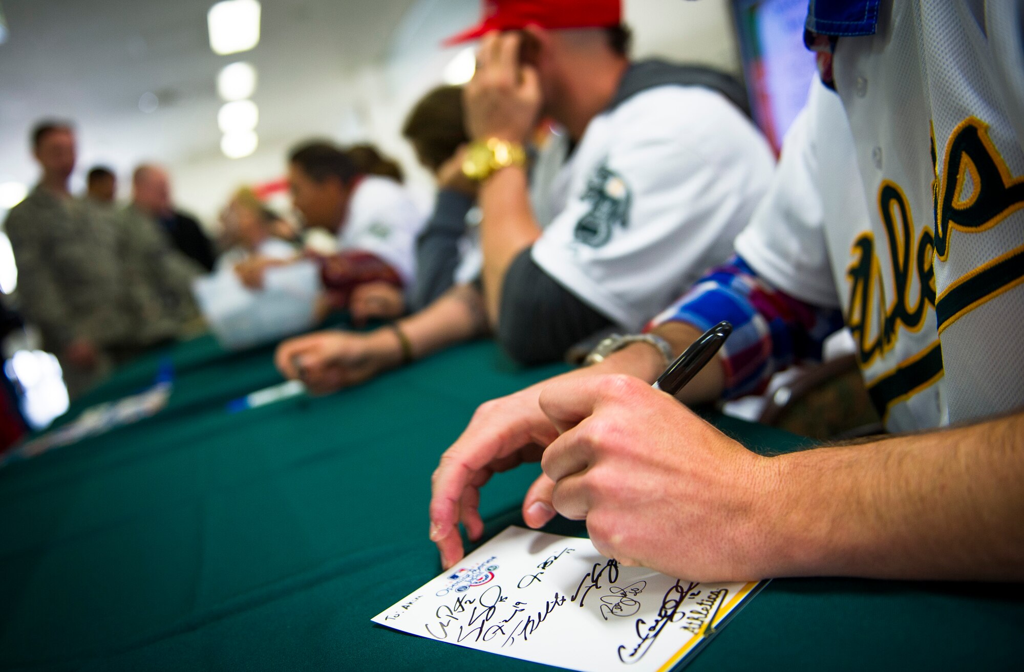 YOKOTA AIR BASE, Japan -- Jerry Blevins, Oakland Athletics relief pitcher, signs his autograph for a fan here at Yokota Air Base, Japan, March 25, 2012. After eating lunch with Airmen in the Samurai Cafe, players signed autographs for more than an hour. (U.S. Air Force photo/Staff Sgt. Chad C. Strohmeyer)
