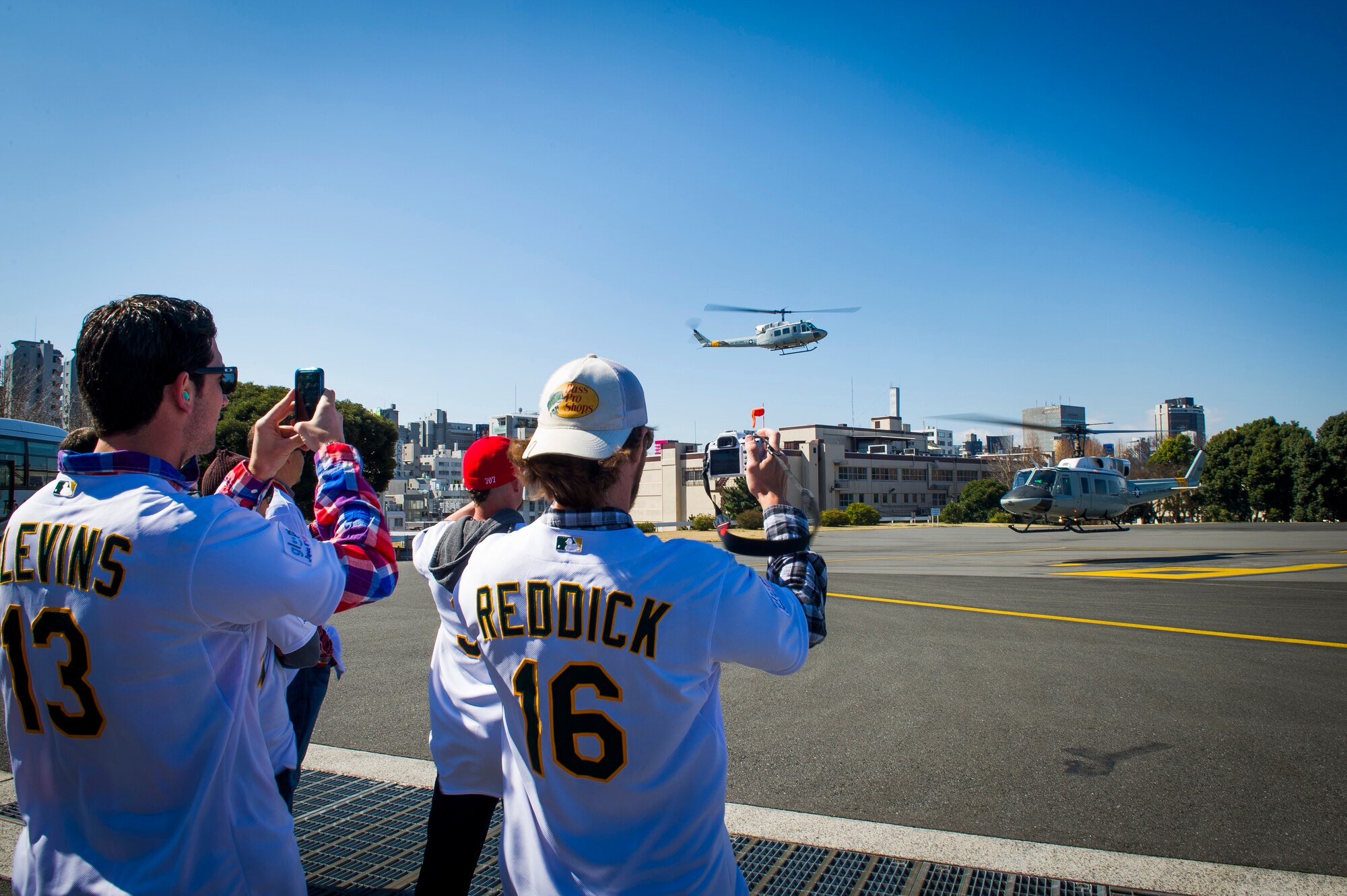 YOKOTA AIR BASE, Japan -- Jerry Blevins, Oakland Athletics relief pitcher and Josh Reddick, Oakland Athletics right fielder, take photos of a UH-1N Iroquois landing at Hardy Barracks March 25, 2012. Eight players from the Oakland Athletics came to visit children and Airmen at Yokota Air Base before their game against the Seattle Mariners on March 28, 2012. (U.S. Air Force photo/Staff Sgt. Chad C. Strohmeyer)