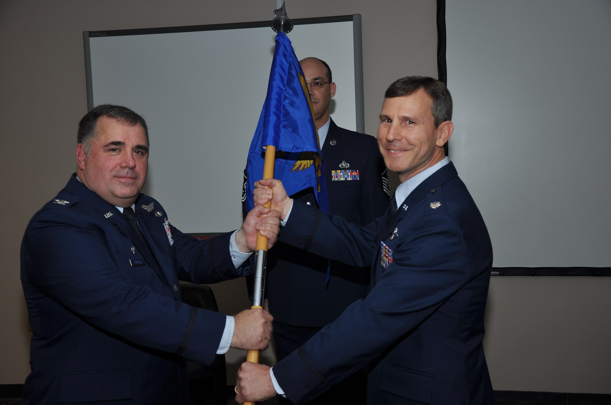 Col. Terry Lawrence, 315th Operations Group Commander, presents the guidon to Lt. Col. Stan Davis as he receives command of the 315th Operations Support Squadron during a Change of Command ceremony here March 24. (U.S. Air Force photo/Tech. Sgt. Scott Mathews)