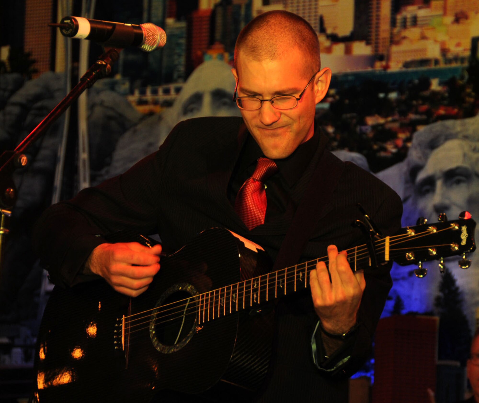U.S. Air Force Airman 1st Class Lee Heerspink, male vocalist in the U.S. Air Forces Central Band, Night Wing, jams on his acoustic guitar during a performance at an undisclosed location, Southwest Asia, Mar. 21, 2012.  The band, deployed from Offutt Air Force Base, Neb., is a country and rock music ensemble visiting countries around the U.S. Central Command area of responsibility, bringing an eclectic mix of new and classic tunes to the delight of host nation civilians and military members. (U.S. Air Force photo/Staff Sgt. James Lieth)
