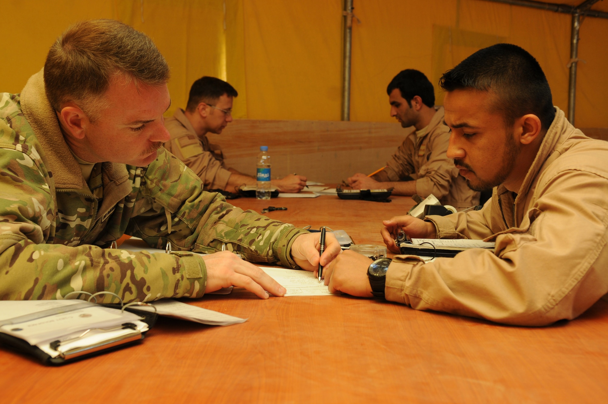 Maj. David McManaway, 444th Air Expeditionary Advisory Squadron assistant director of operations and instructor pilot, discusses the weight and balance of an Afghan Cessna 182 aircraft with Afghan air force Lt. Wahlid Noori before taking flight in a Cessna 182 aircraft at Shindand Air Base, Afghanistan, March 24, 2012. Norri was one of three student pilots to perform Afghanistan’s first fixed-wing undergraduate pilot training flights in more than 30 years. (U.S. Air Force photo by Staff Sgt. Nadine Y. Barclay)

