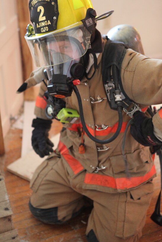 A firefighter from Marine Corps Base Camp Lejeune’s Fire Station Two works his way through the maze of obstacles in a training facility constructed at MCB Camp Lejeune’s Midway Park housing area. The firefighters built the facility at no cost to the base by utilizing waste materials to convert a house scheduled for demolition.