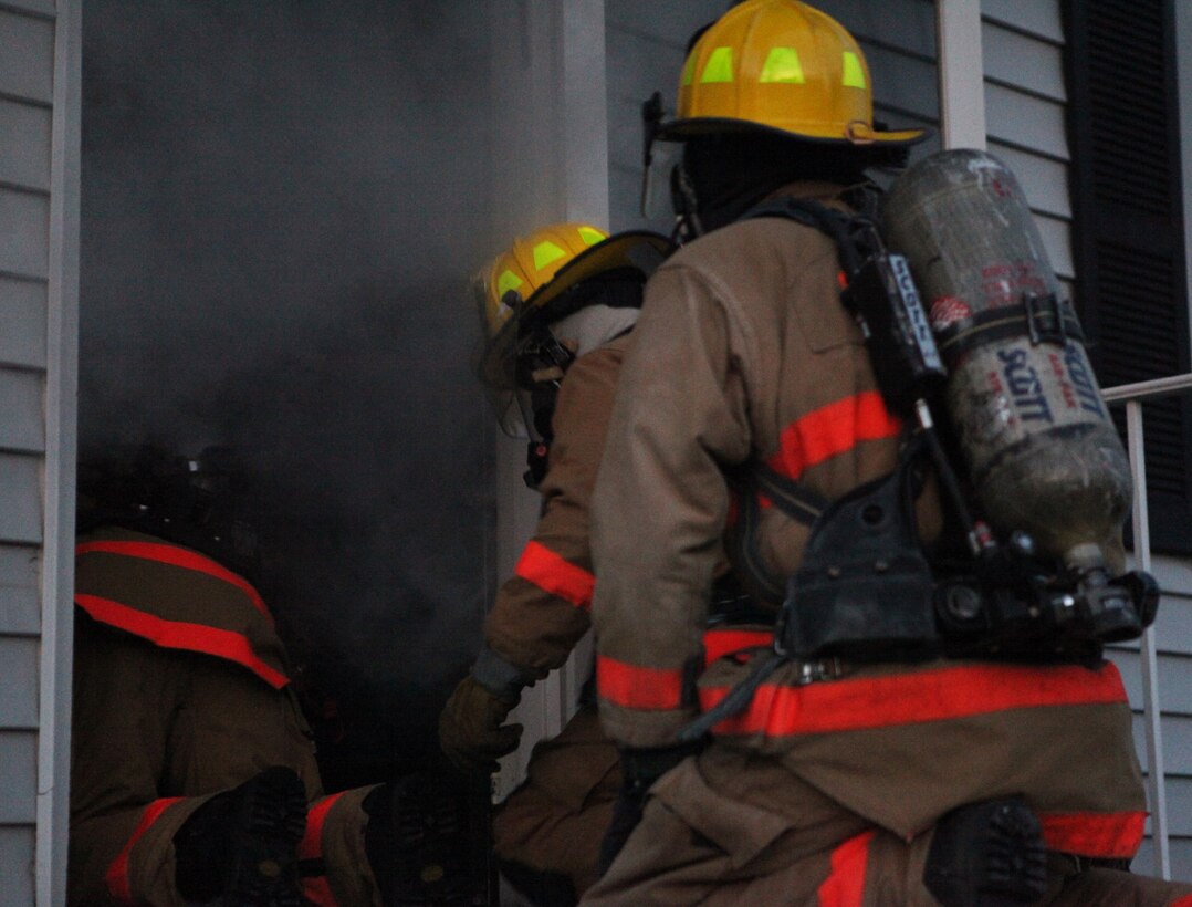 Three firefighters from Marine Corps Base Camp Lejeune’s Security and Emergency Services enter a house filled with smoke and obstacles, March 26. The house is part of a training facility built by the firefighters at no cost to MCB Camp Lejeune.