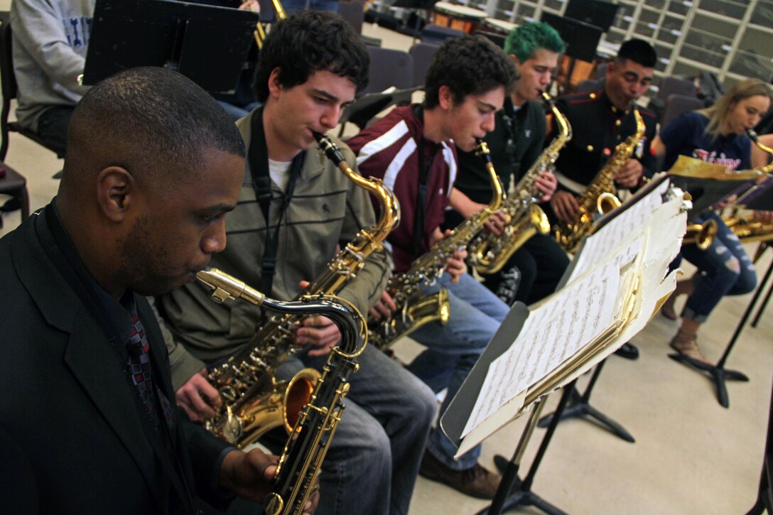 Gunnery Sgt. Jason Knuckles, 9th Marine Corps District Marine band placement director, and members of the Parris Island and San Diego Marine Corps bands perform with the Denfeld High School students while touring Northern Minnesota March 26. The Marine musicians also visited several high schools in Western Wisconsin. Their trip will conclude after performing at the Eau Claire Jazz Festival on March 30. For additional imagery involving their tour, visit www.facebook.com/rstwincities.
