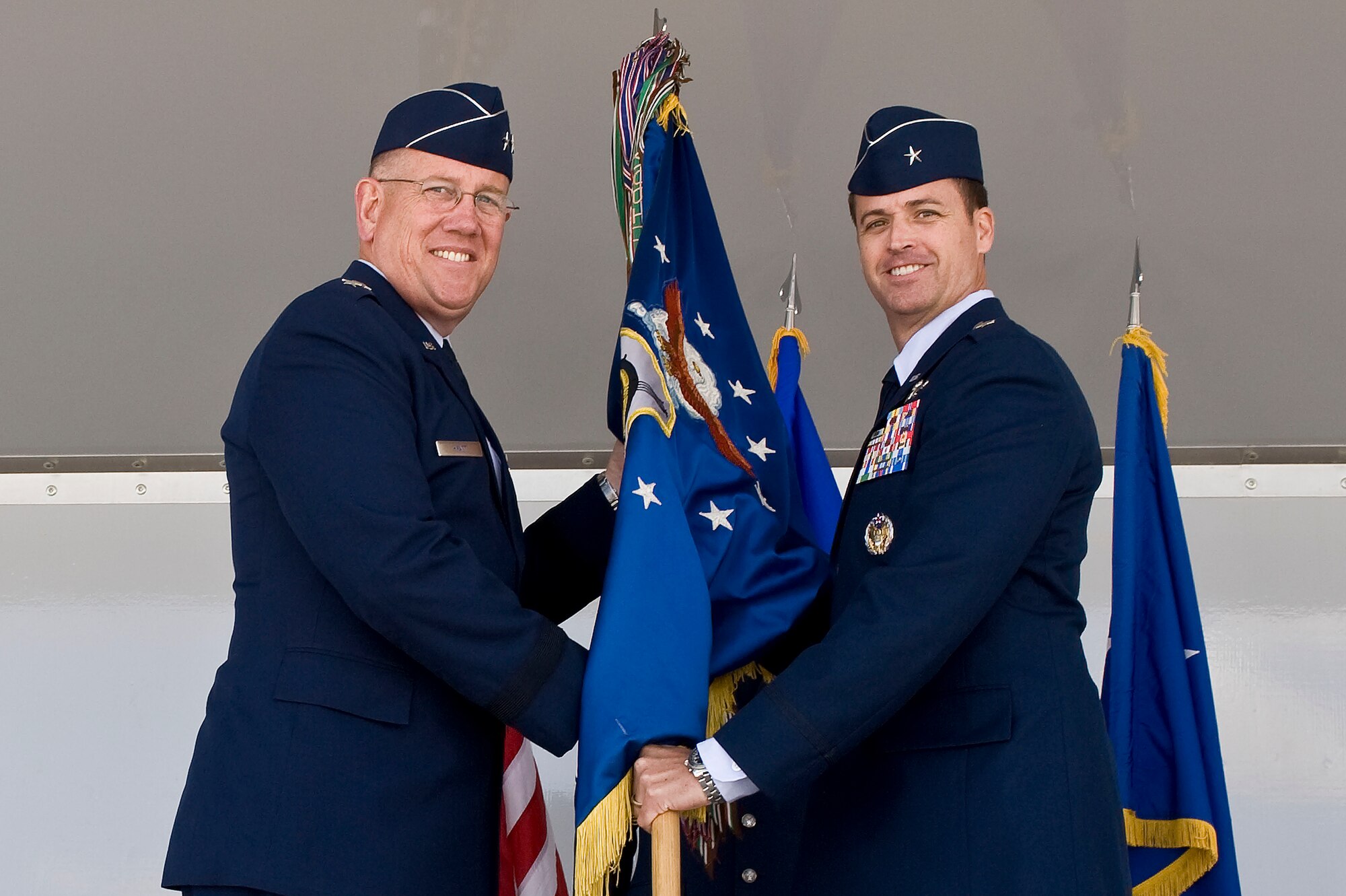 U.S. Air Force Maj. Gen. James W. Hyatt, US Air Force Warfare Center commander, and Brig. Gen. Charles L. Moore Jr., 57th Wing commander, pose during the passing of the wing's guidon at a change of command ceremony March 26, 2012 at Nellis Air Force Base, Nev. Moore assumed command of one the largest composite wings in the AF, providing advanced aerospace training to world-wide combat air forces. (U.S. Air Force photo by Airman 1st Class Matthew Lancaster)