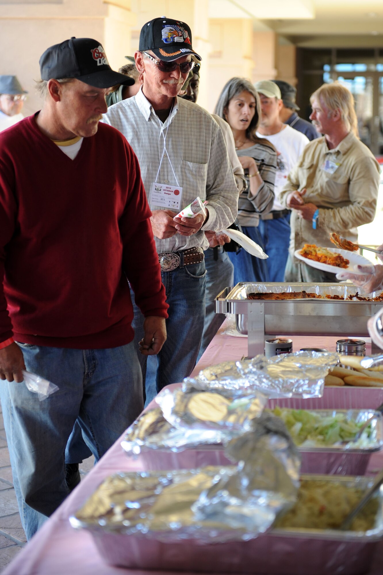 Local veterans line up for a lasagna dinner while attending the 2012 Las Vegas Veterans Stand Down, March 21.  The ninth annual Veterans Stand Down was held at the East Las Vegas Senior Community Center. The two-day event offered local veterans the chance to get a hot meal, information on veterans services and the opportunity to meet other veterans in the area.  (U.S. Air Force photo by Staff Sgt. Taylor Worley)

