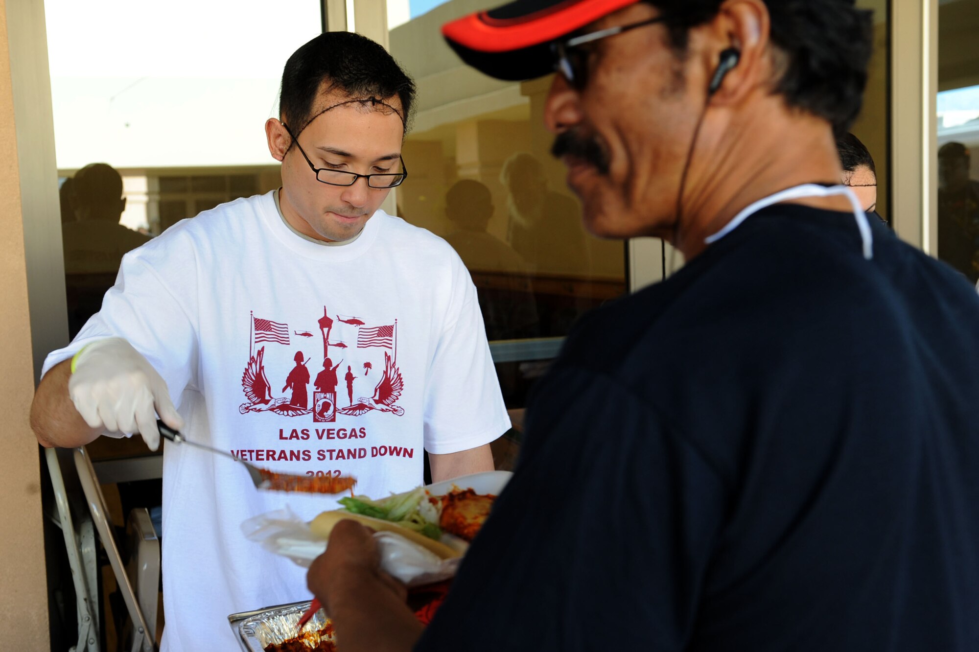 U.S. Air Force Staff Sgt. Joel Gurrero, 99th Medical Support Squadron information systems technician, serves lunch to local veterans during the 2012 Las Vegas Veterans Stand Down, March 21, 2012.  Hundreds of veterans attended the ninth annual Veterans Stand Down at the East Las Vegas Senior Community Center. The two-day event featured more than 100 community sponsors who offered assistance on health, housing, employment and legal advice. (U.S. Air Force photo by Staff Sgt. Taylor Worley)

