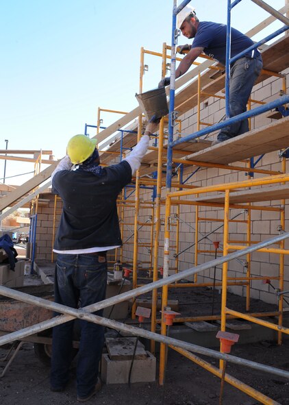 Construction workers finish a new building that will house the necessary equipment and supplies to keep the Liberty Pool clean & running properly at Cannon Air Force Base, N.M., March 16, 2012. After the completion of the pool, the groundwork for the addition of a new pool deck will begin.  (U.S. Air Force photo by Airman 1st Class Eboni Reece)