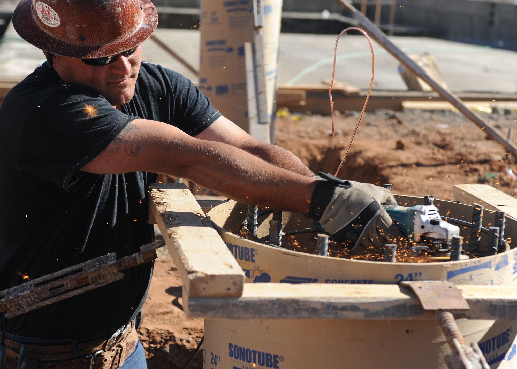 A construction worker uses an electric saw to cut steel bars in the swimming pool construction site on March 16, 2012 at Cannon Air Force Base, N.M. The contractors have set a goal to have Cannon's Liberty pool completed by Memorial Day weekend.(U.S. Air Force photo by Airman First Class Eboni Reece)