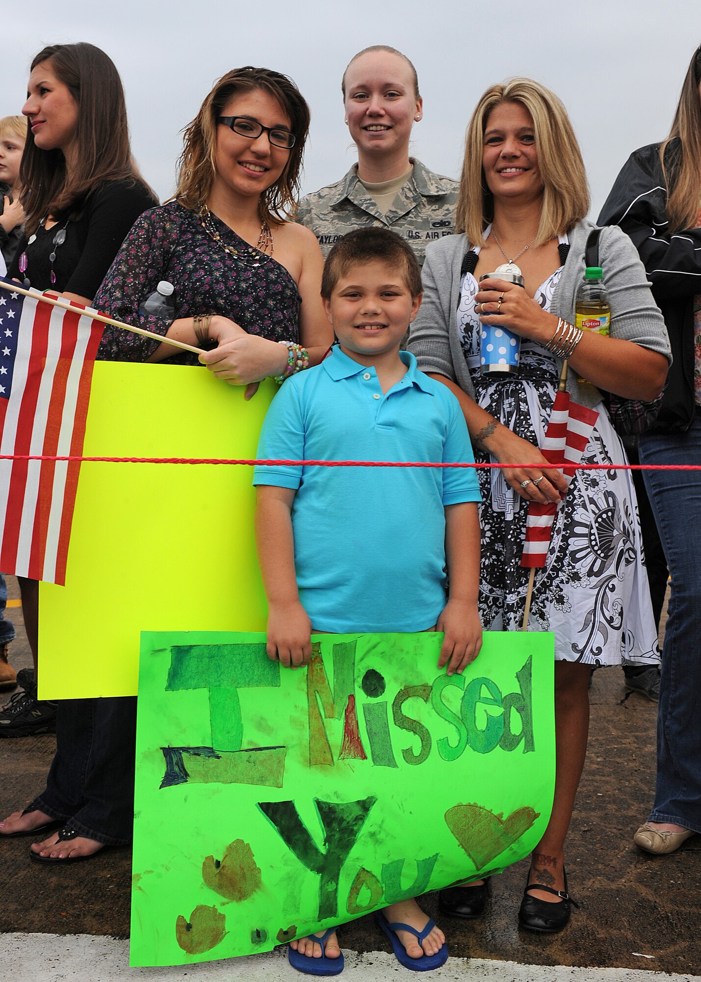 U.S. Staff Sgt. Michelle Taylor, along with Kasie, Dallas and Miranda, await the arrival of U.S. Air Force Staff Sgt. Tracy Elliot at Seymour Johnson Air Force Base, N.C., March 26, 2012. Elliot deployed to Bagram Airfield, Afghanistan, in support of Operation Enduring Freedom. Elliot, 4th Equipment Maintenance Squadron munitions technician, is a native of Bedford, Pa. Taylor, 4th EMS munitions technician, is from Chesapeake, Va. (U.S. Air Force photo/Airman 1st Class John Nieves Camacho/Released)