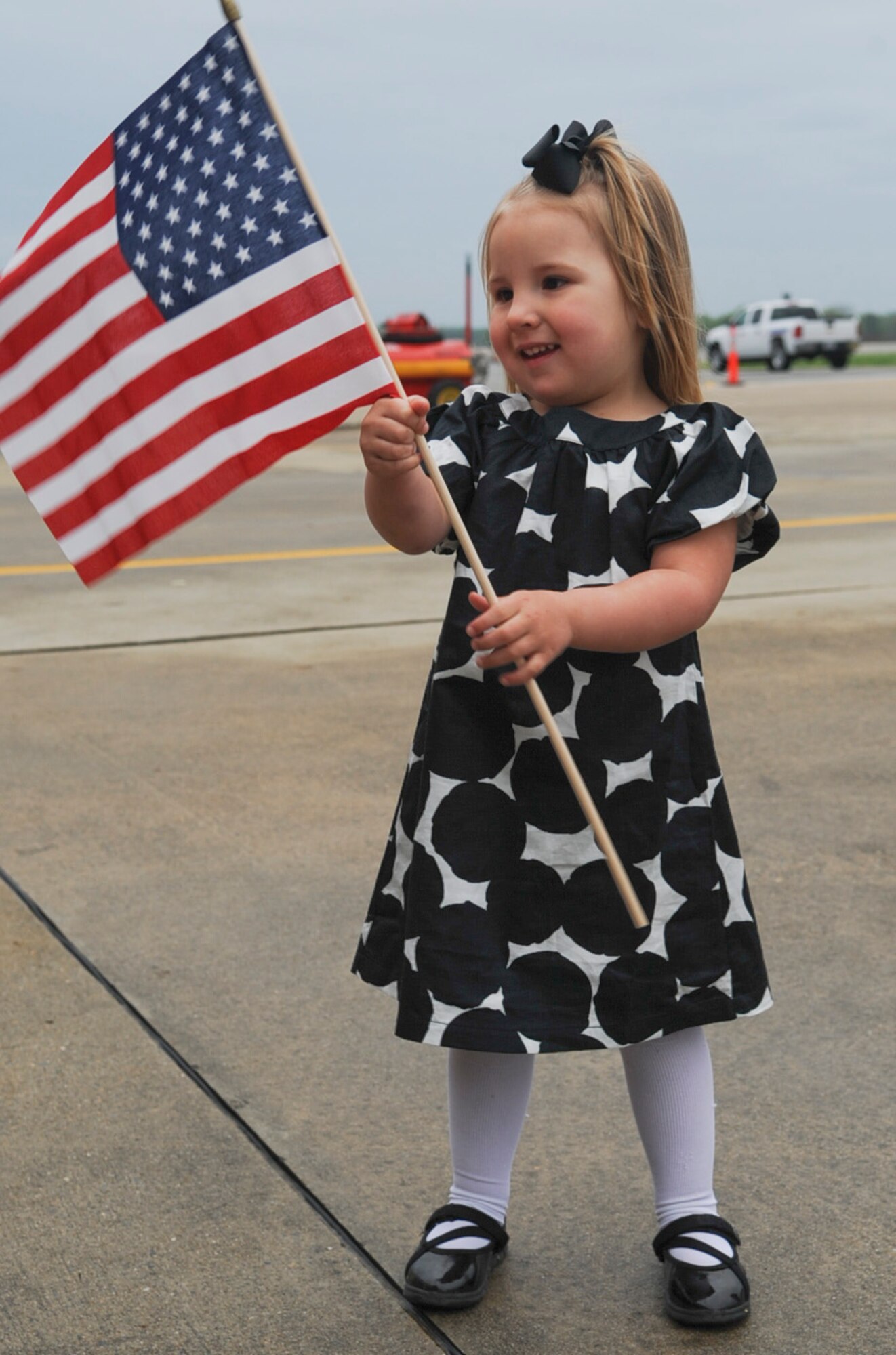 Palyn Sloan admires the American flag as she waits for her godfather, U.S. Air Force Airman 1st Class Collin Platt, on Seymour Johnson Air Force Base, N.C., March 26, 2012. Sloan has not seen her godfather in six months due to a deployment to Bagram Airfield, Afghanistan. Platt, 335th Aircraft Maintenance Unit, hails from Connecticut. (U.S. Air Force photo/Airman 1st Class Aubrey Robinson/Released)