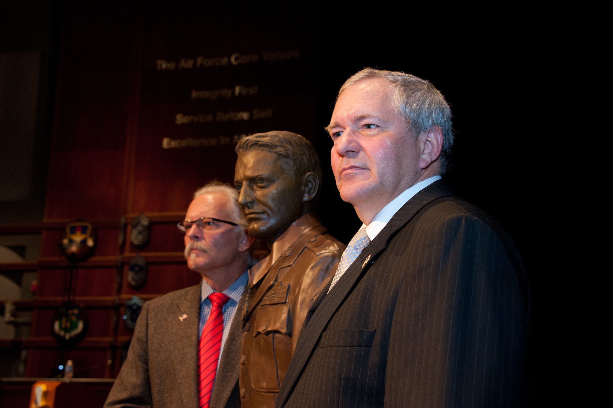 The sons of Chief Master Sergeant Richard L. Etchberger flank the statue of their father following its official unveiling on March 26, 2012.  Rich Etchberger, left, and Cory Etchberger,right, joined other family members and dignitaries including General Philip Breedlove, Vice Chief of Staff of the Air Force, and Chief Master Sergeant James Roy, Chief Master Sergeant of the Air Force, in honoring their father's legacy with the dedication of his medal of honor and the bust unveiling at the Air Force Senior Noncommissioned Officer Academy. (U.S. Air Force photo by Melanie Rodgers Cox)